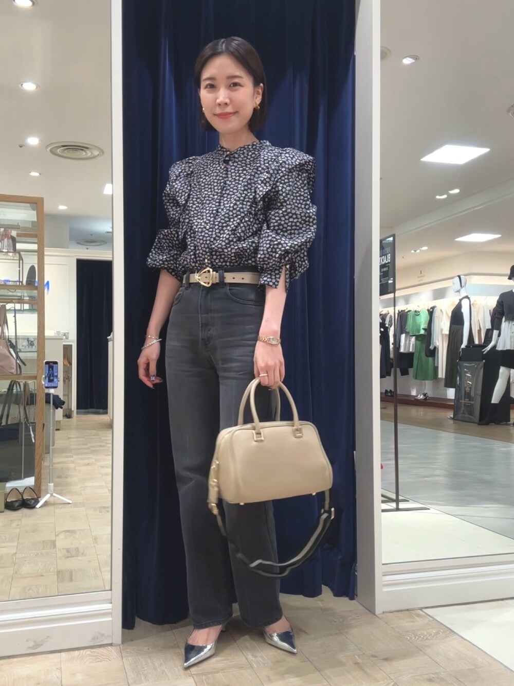 ベージュ系のショルダーバッグ、グレー系のデニムパンツ、ブラック系のシャツ/ブラウスを着用したレディースの秋コーディネートの3枚目の写真