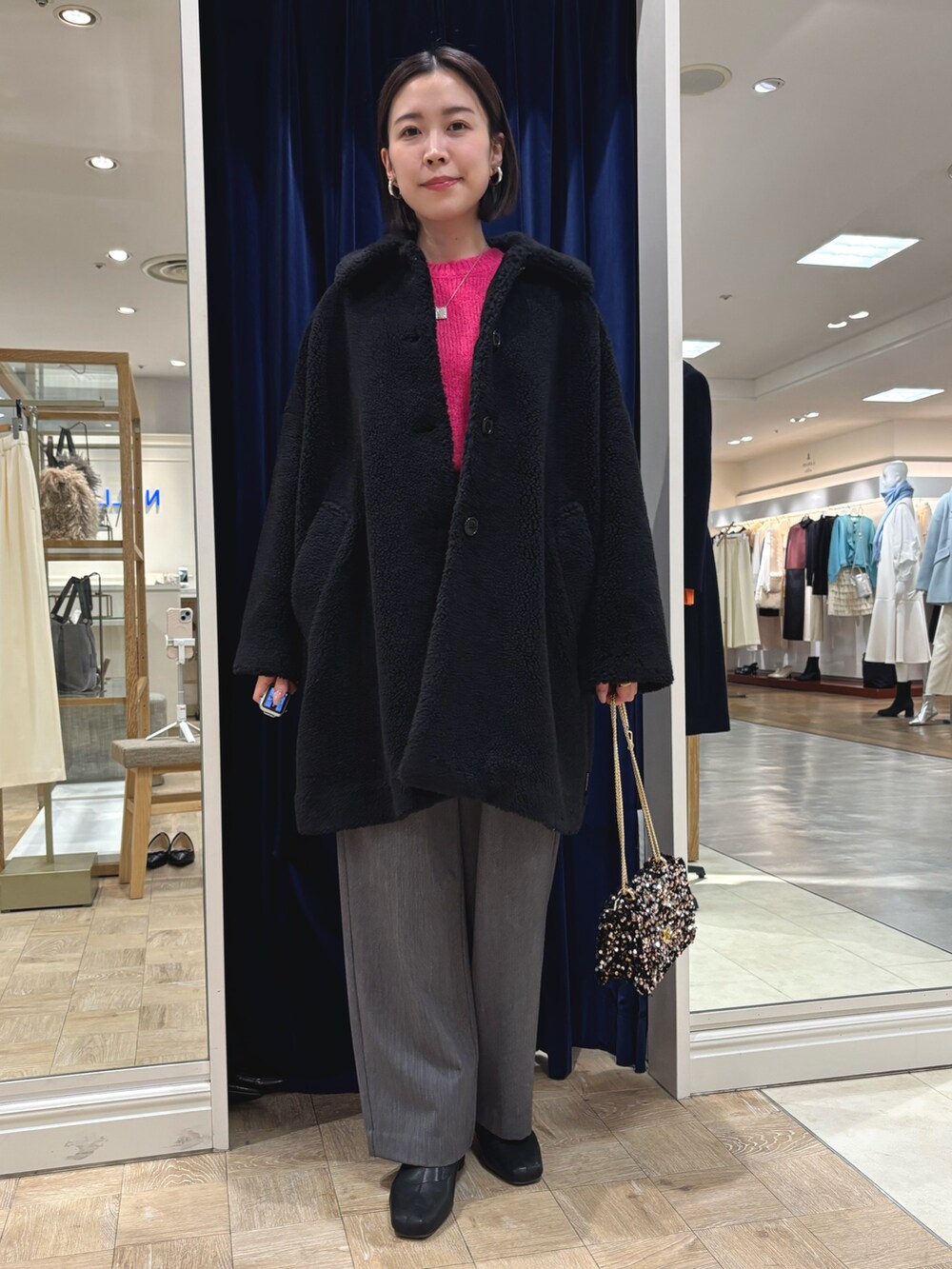 ピンク系のニット/セーター、ブラック系のダッフルコート、その他のショルダーバッグを着用したレディースの冬コーディネートの5枚目の写真