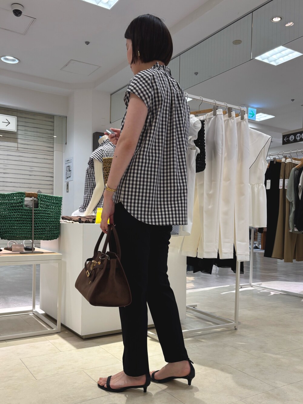 ブルー系のシャツ/ブラウス、ブラック系のその他パンツ、ブラウン系のトートバッグを着用したレディースの夏コーディネートの3枚目の写真