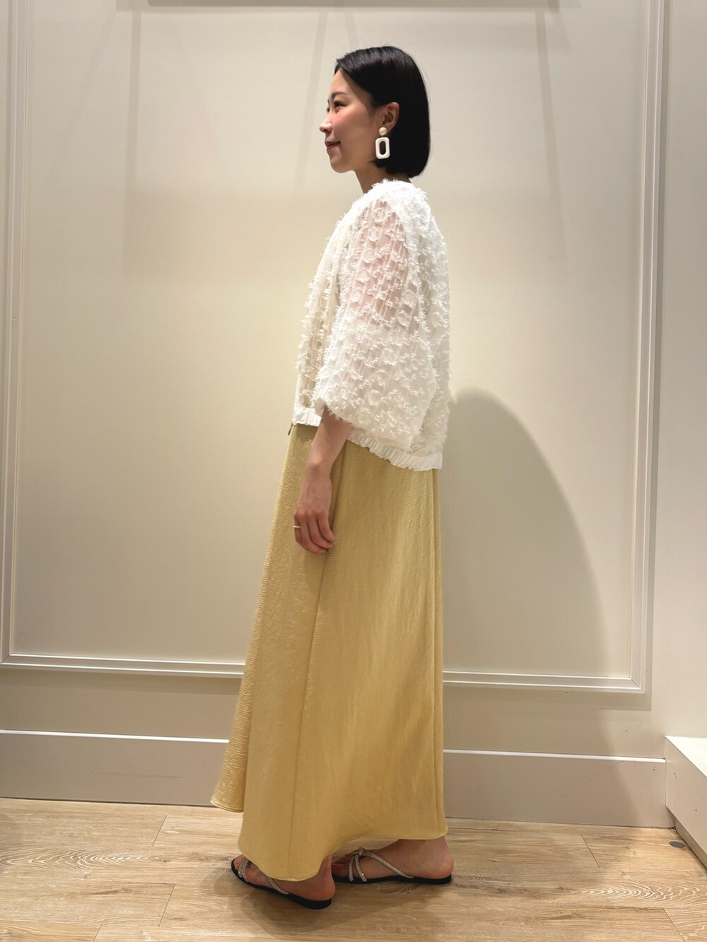 イエロー系のワンピース、ホワイト系のブルゾン、ホワイト系のTシャツ/カットソーを着用したレディースの夏コーディネートの3枚目の写真