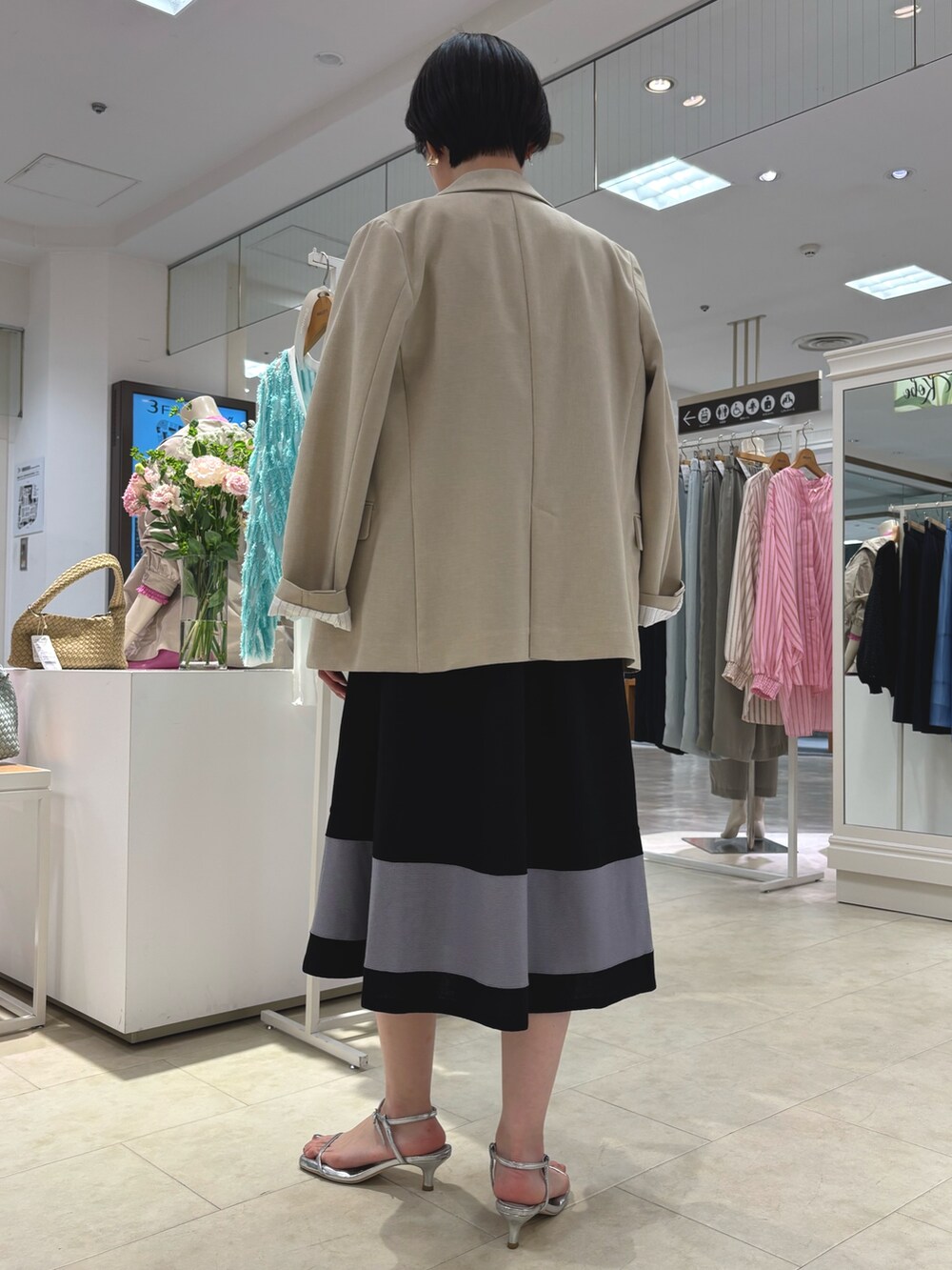 ベージュ系のテーラードジャケット、ブラック系のワンピース、ゴールド系のネックレスを着用したレディースの春コーディネートの4枚目の写真