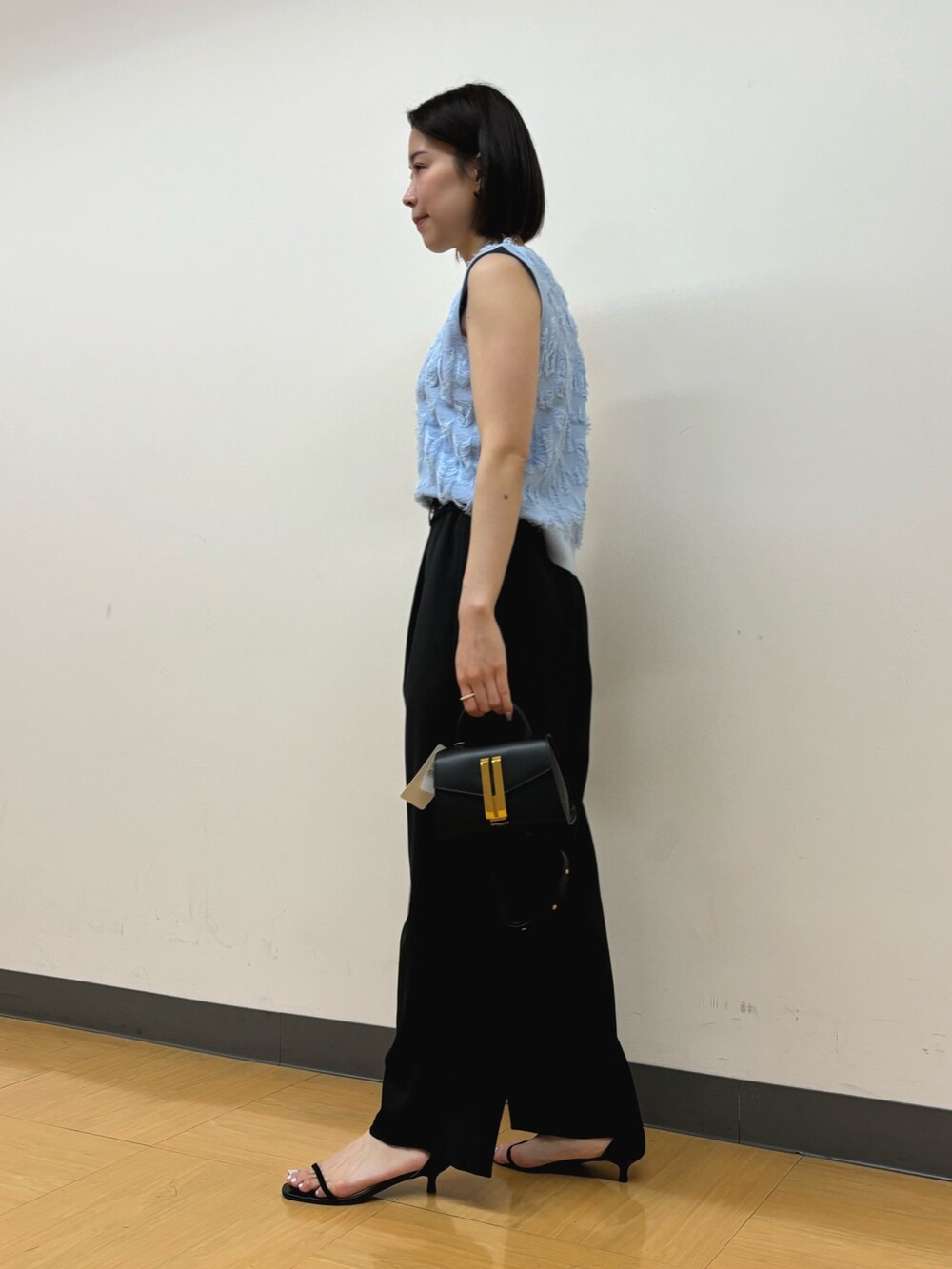 ブラック系のその他パンツ、ブラック系のハンドバッグ、ブルー系のニット/セーターを着用したレディースの春コーディネートの3枚目の写真