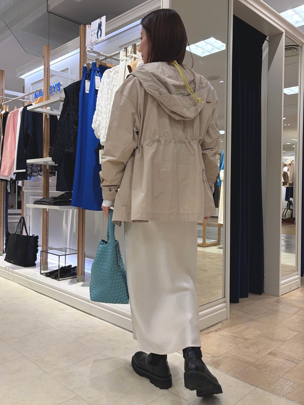 ベージュ系のブルゾン、ホワイト系のスカート、ブルー系のショルダーバッグを着用したレディースの春コーディネートの4枚目の写真