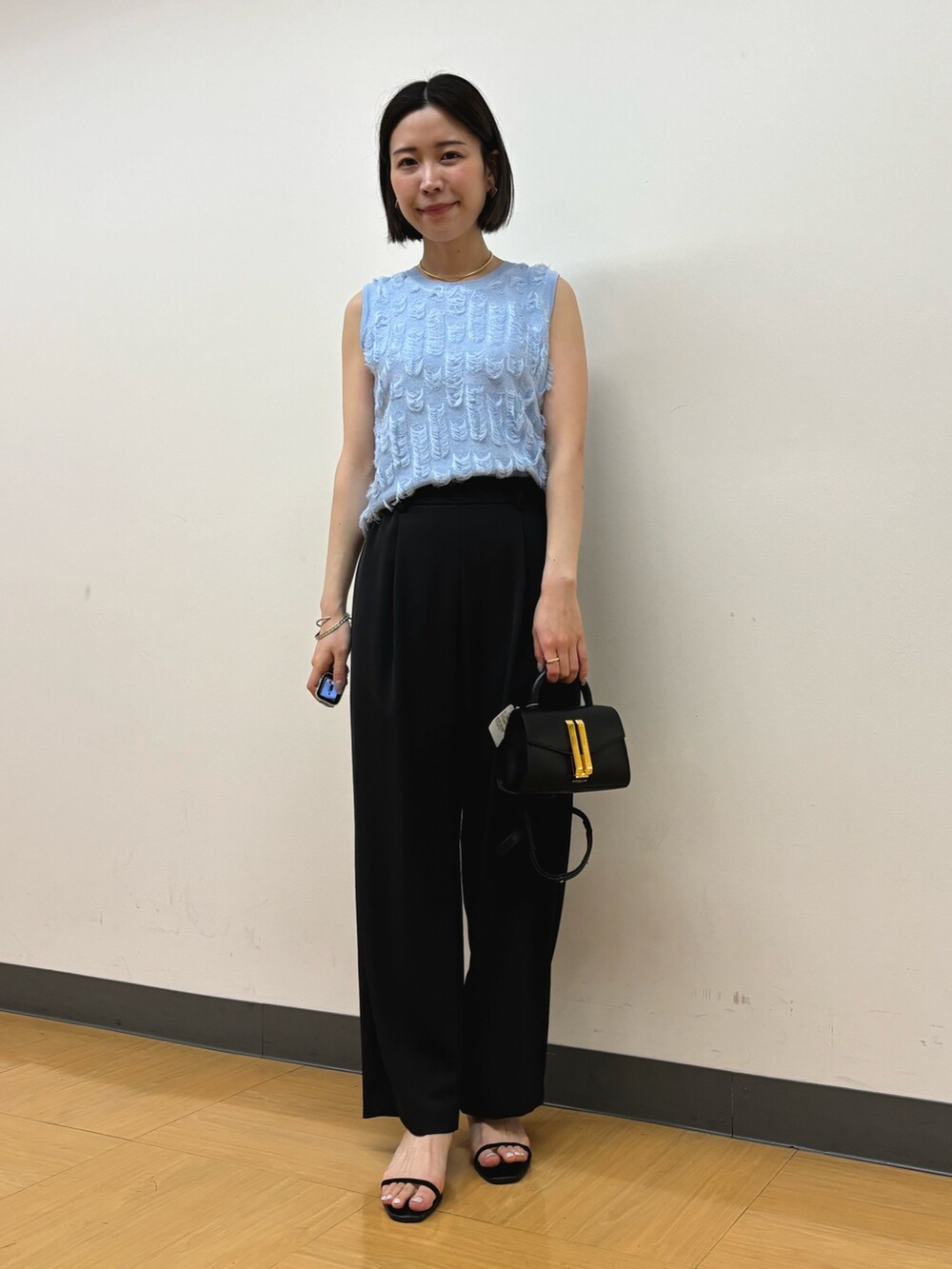 ブラック系のその他パンツ、ブラック系のハンドバッグ、ブルー系のニット/セーターを着用したレディースの春コーディネートの2枚目の写真