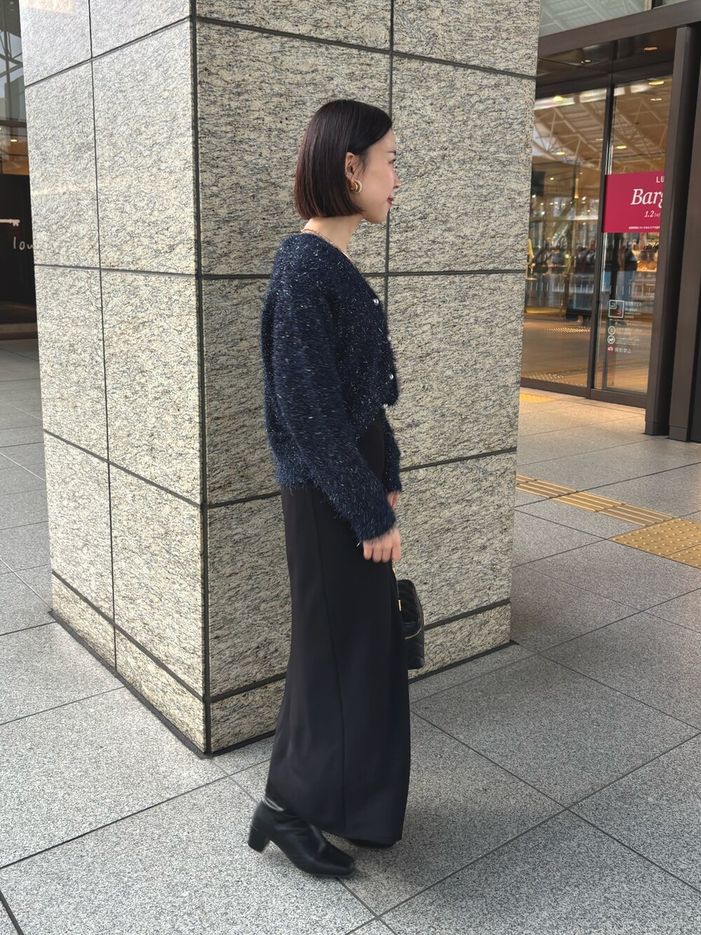 ブラック系のスカート、ブラック系のショルダーバッグ、ブルー系のカーディガン/ボレロを着用したレディースの冬コーディネートの4枚目の写真