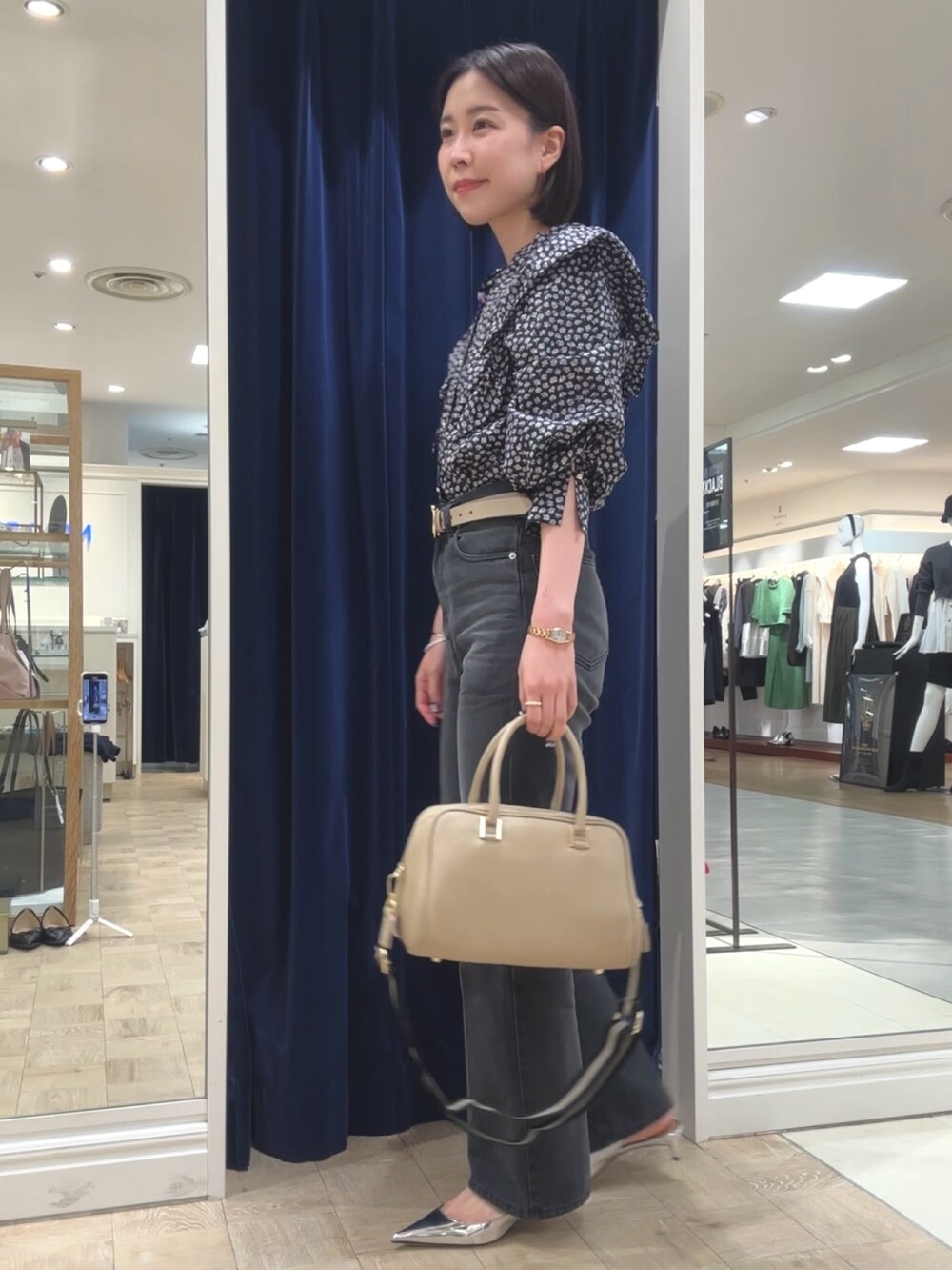 ベージュ系のショルダーバッグ、グレー系のデニムパンツ、ブラック系のシャツ/ブラウスを着用したレディースの秋コーディネートの4枚目の写真