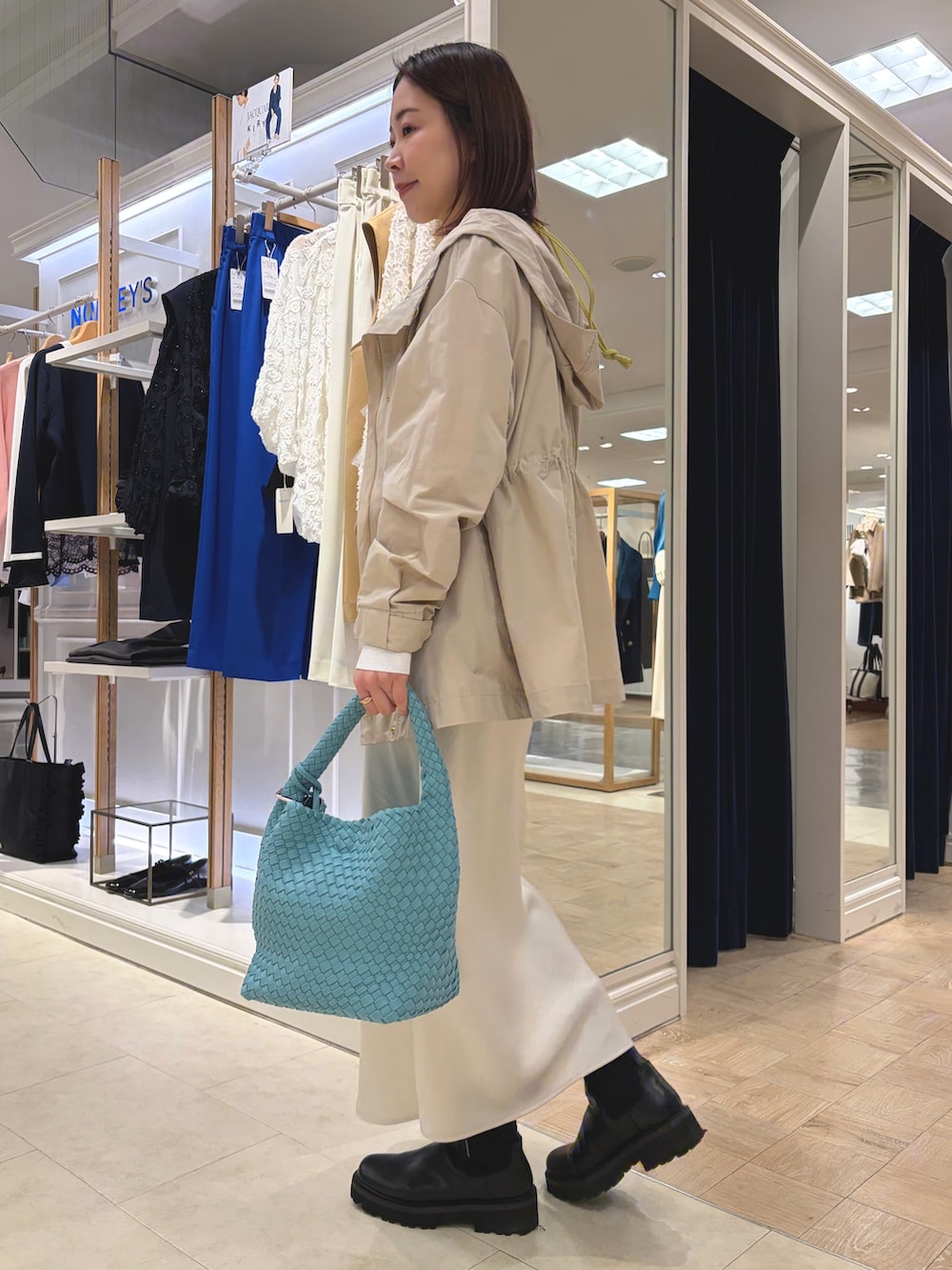 ベージュ系のブルゾン、ホワイト系のスカート、ブルー系のショルダーバッグを着用したレディースの春コーディネートの3枚目の写真