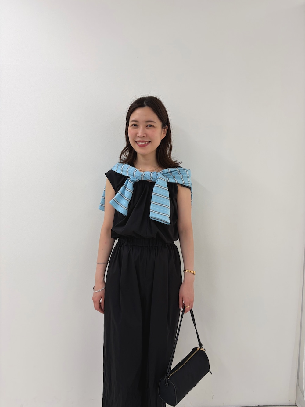 ブラック系のつなぎ/オールインワン、ブルー系のカーディガン/ボレロ、ブラック系のショルダーバッグを着用したレディースの夏コーディネートの6枚目の写真
