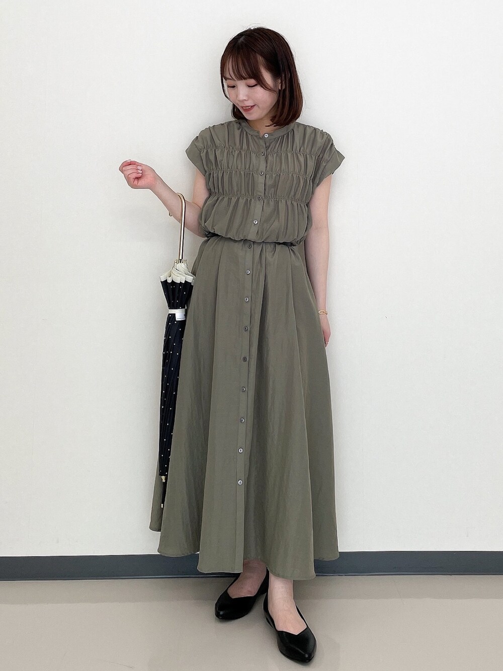 グリーン系のワンピース、ブラック系のその他シューズ、ブラック系の長傘を着用したレディースの夏コーディネートの3枚目の写真