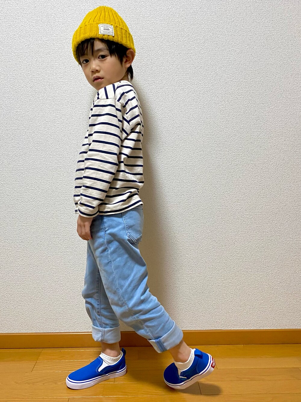 ホワイト系のトップス、ブルー系のデニムパンツ、ブルー系のスリッポンを着用したキッズの冬コーディネートの3枚目の写真