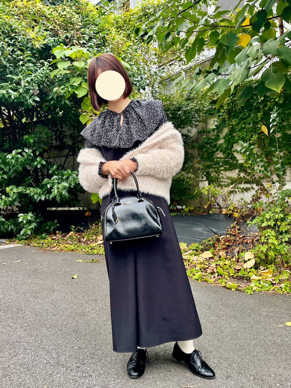 ブラック系のトートバッグ、ベージュ系のカーディガン/ボレロ、ブラック系のシャツ/ブラウスを着用したレディースの秋コーディネートの2枚目の写真