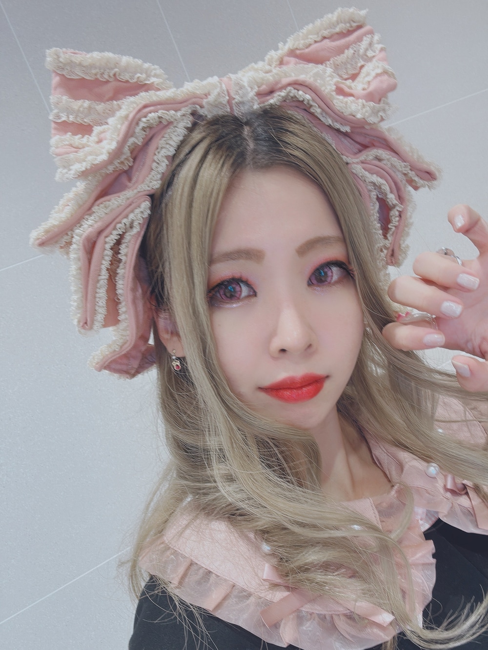 ブラック系のポンチョ、ピンク系のショルダーバッグ、ピンク系のシャツ/ブラウスを着用したレディースの秋コーディネートの3枚目の写真