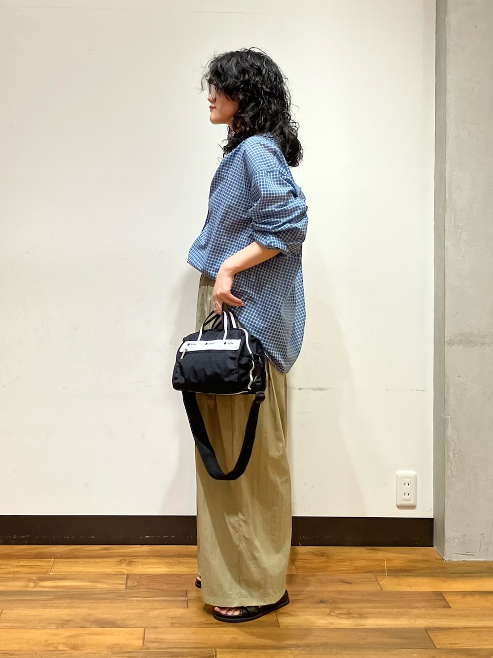 ブラック系のサンダル、ベージュ系のその他パンツ、ブルー系のシャツ/ブラウスを着用したレディースの夏コーディネートの2枚目の写真