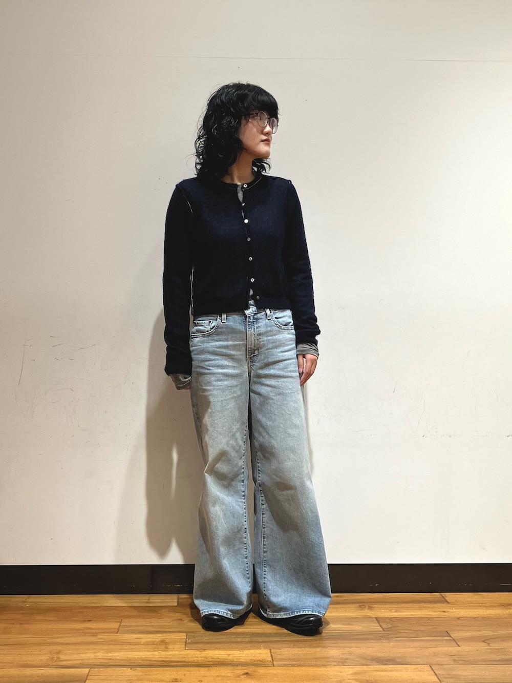 ブラック系のスニーカー、パープル系のダウンジャケット/コート、ブルー系のカーディガン/ボレロを着用したレディースの冬コーディネートの3枚目の写真