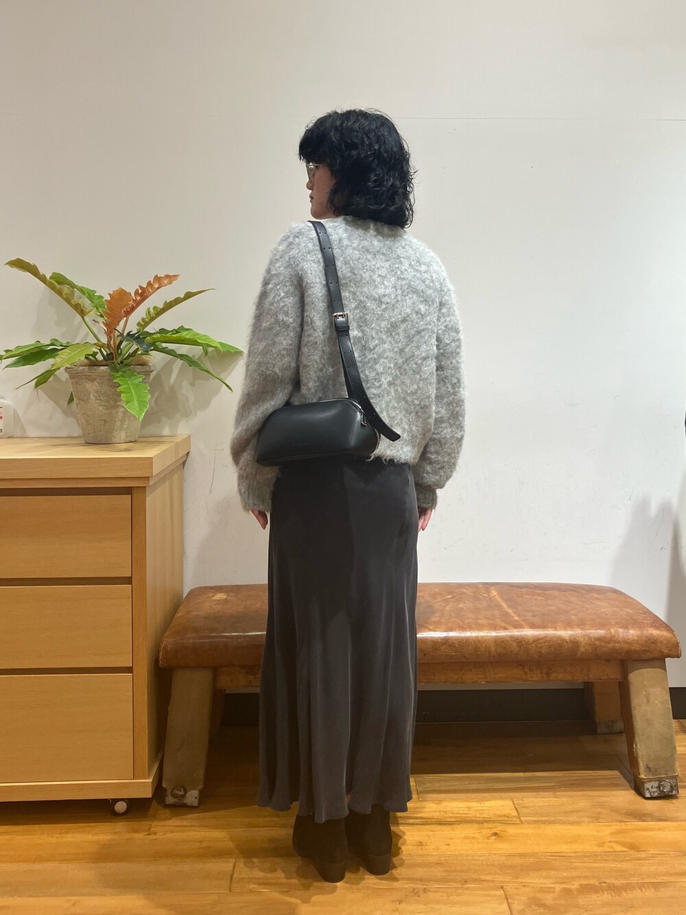 グレー系のスカート、グレー系のカーディガン/ボレロ、ブラック系のショルダーバッグを着用したレディースの秋コーディネートの4枚目の写真