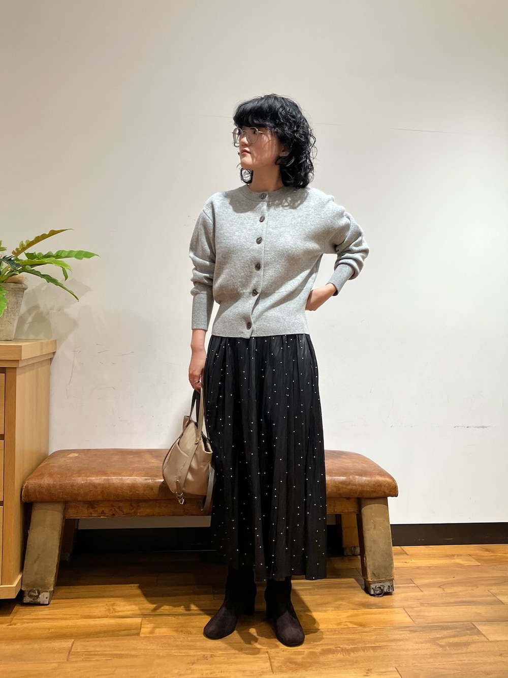 グレー系のカーディガン/ボレロ、ブラック系のスカート、ベージュ系のショルダーバッグを着用したレディースの秋コーディネートの3枚目の写真
