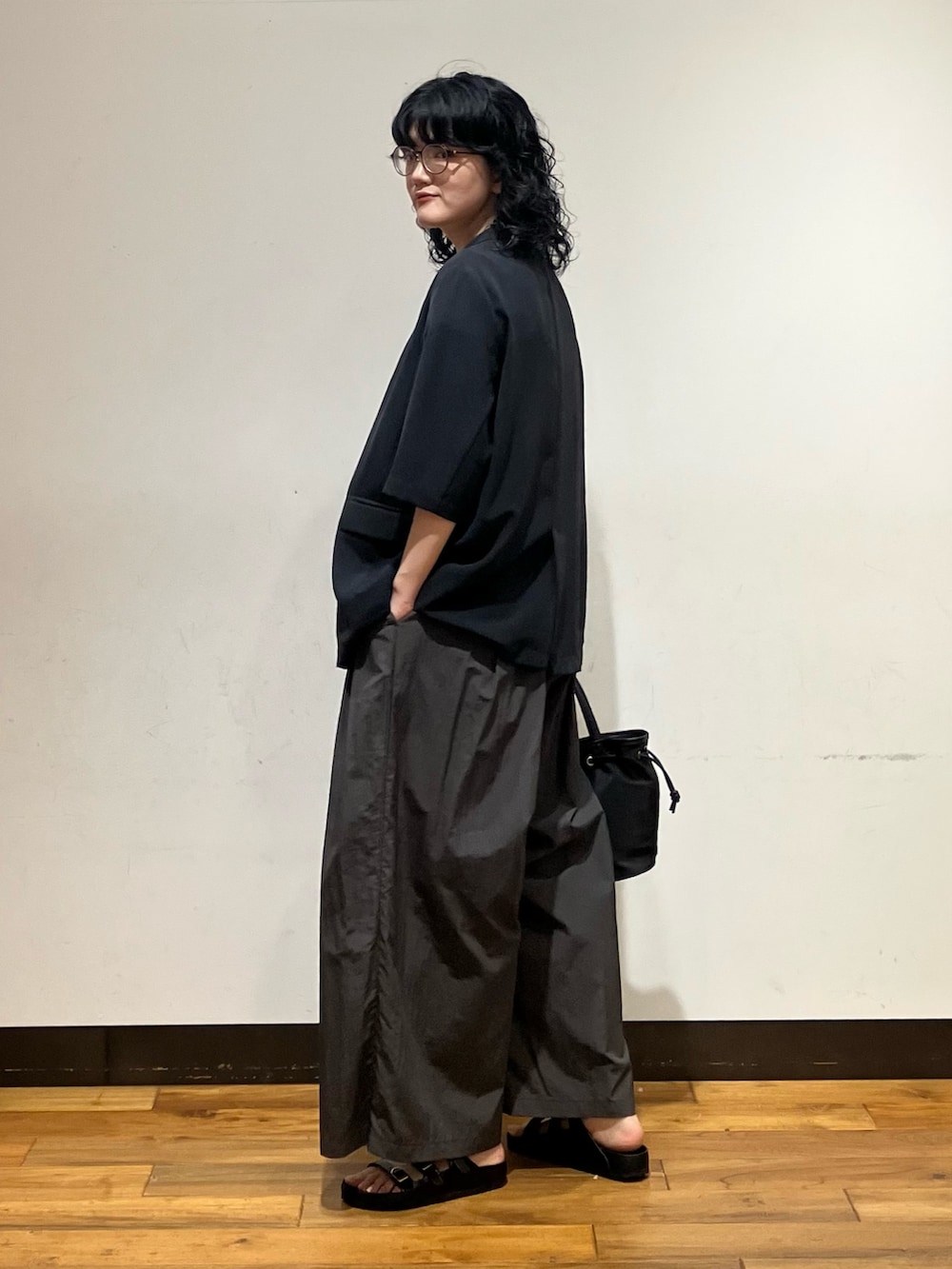 グレー系のその他パンツ、ブラック系のサンダル、ブラック系のトートバッグを着用したレディースの春コーディネートの3枚目の写真