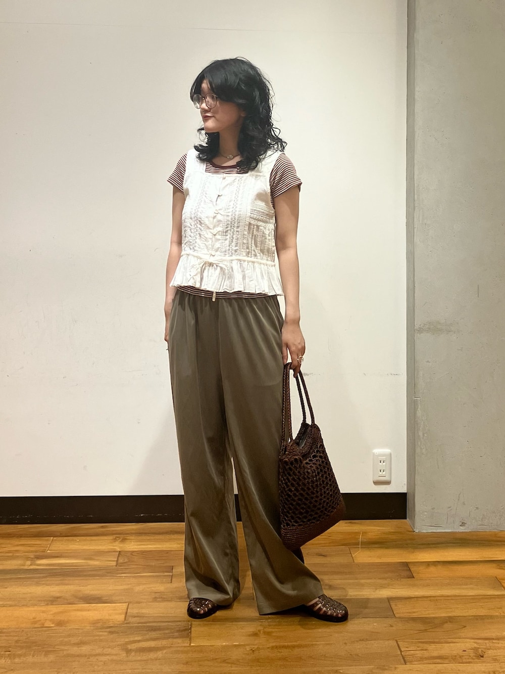 ブラウン系のトートバッグ、ホワイト系のシャツ/ブラウス、ブラウン系のTシャツ/カットソーを着用したレディースの夏コーディネートの2枚目の写真