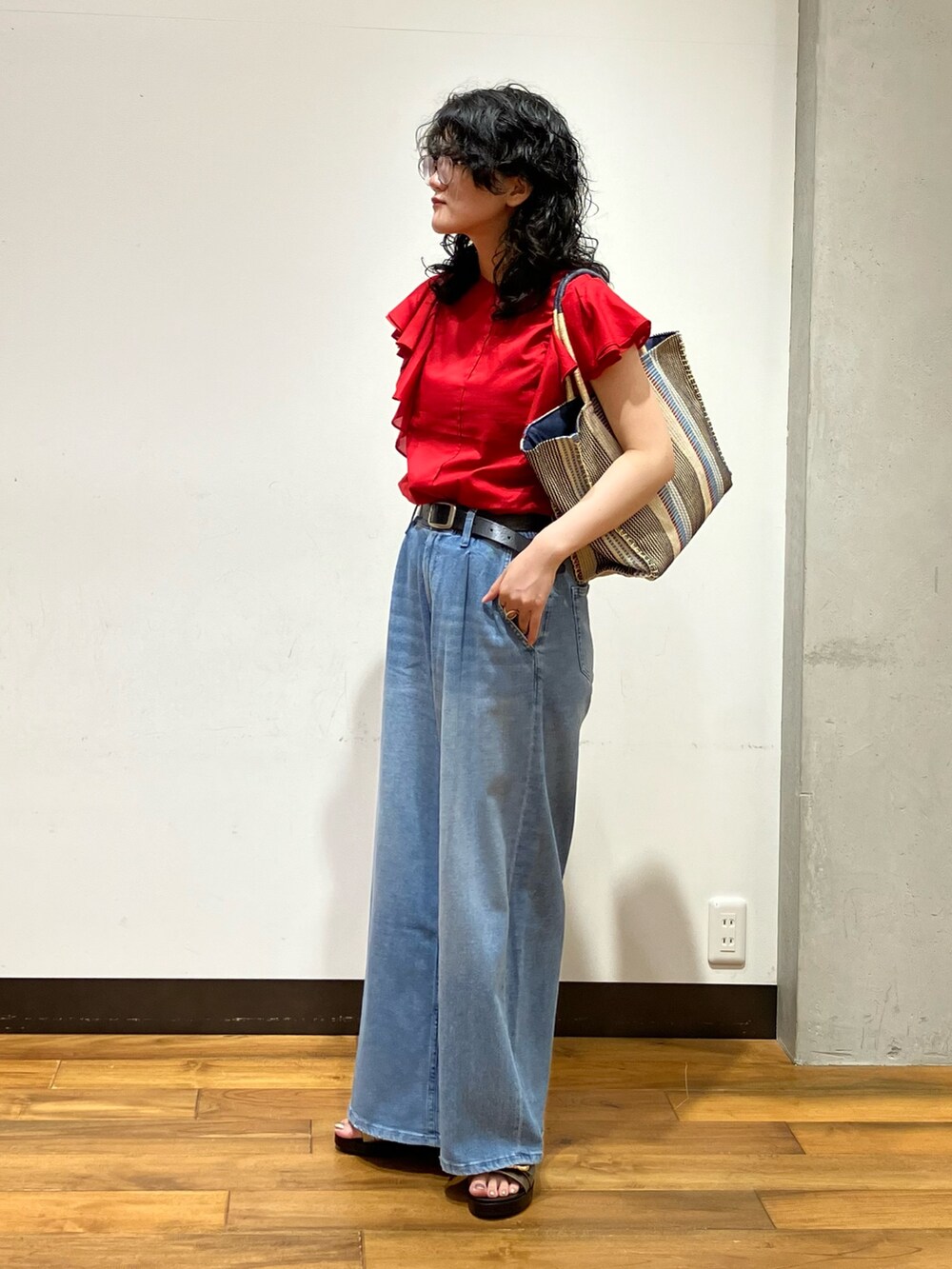 ブルー系のデニムパンツ、レッド系のシャツ/ブラウス、シルバー系のサンダルを着用したレディースの夏コーディネートの3枚目の写真