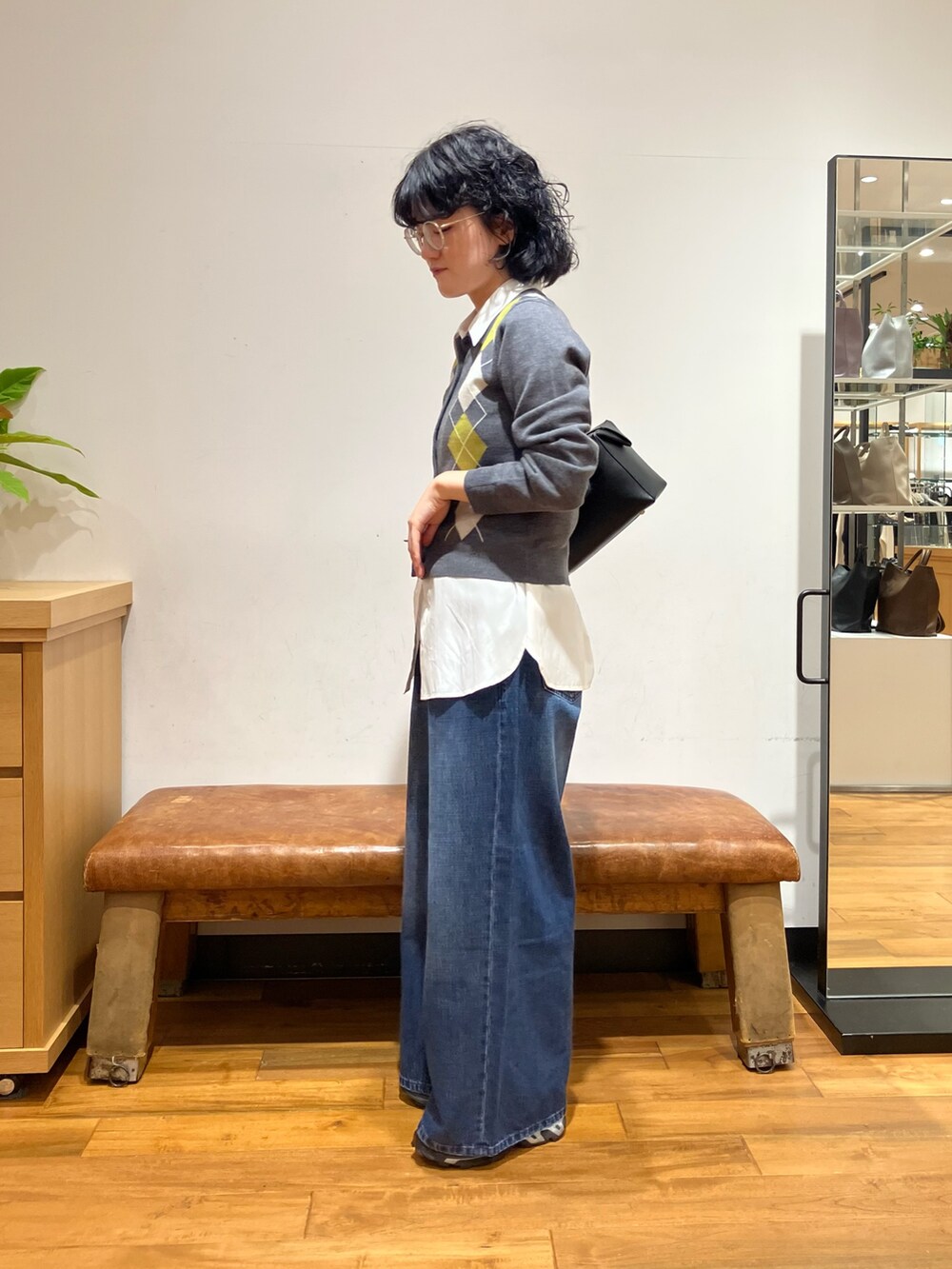 ホワイト系のシャツ/ブラウス、グレー系のニット/セーター、ブルー系のデニムパンツを着用したレディースの秋コーディネートの2枚目の写真