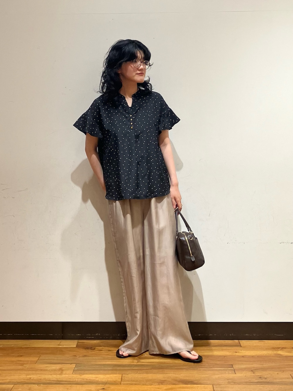 ブラック系のシャツ/ブラウス、ベージュ系のその他パンツ、ブラウン系のボストンバッグを着用したレディースの夏コーディネートの2枚目の写真