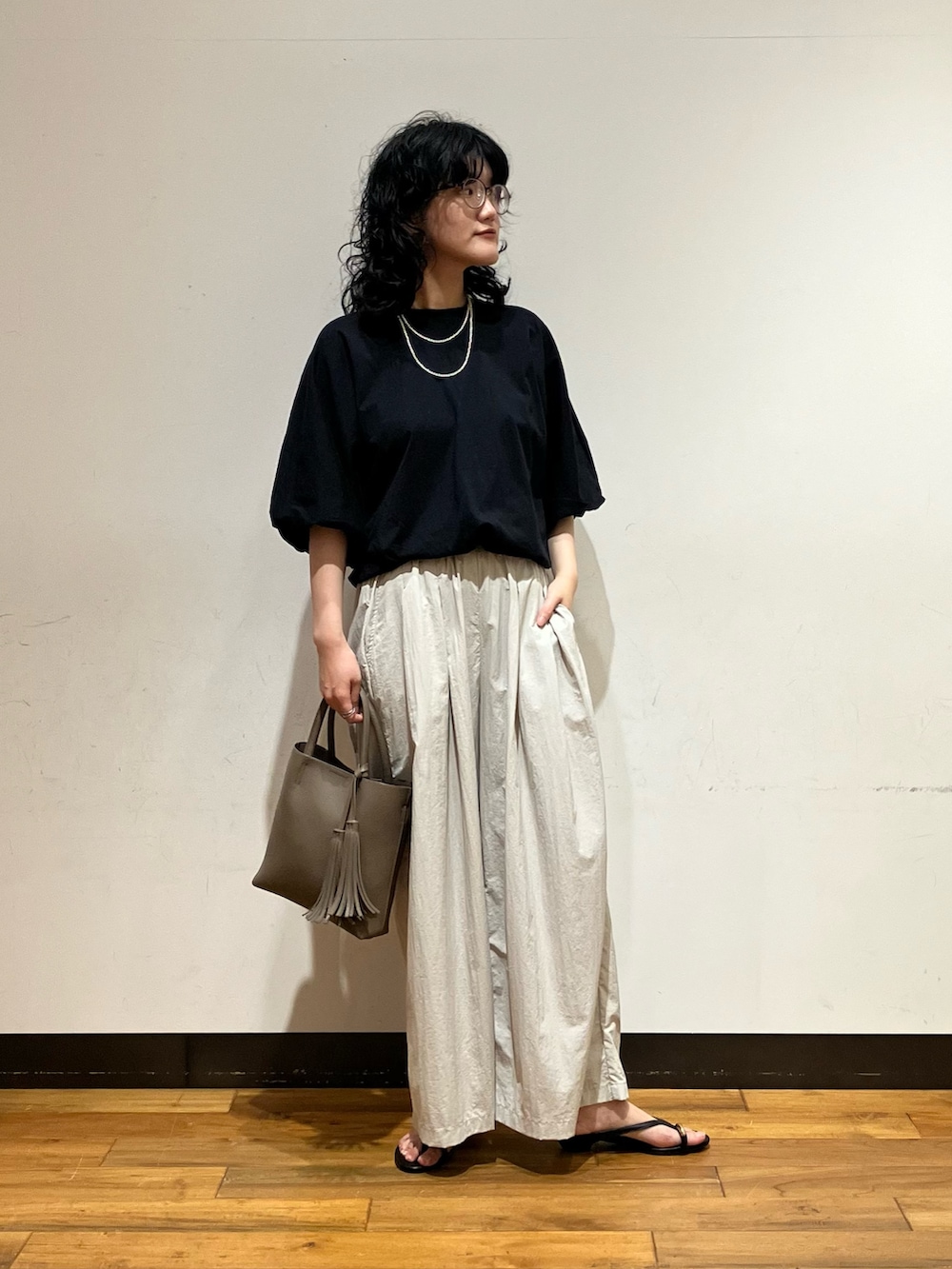 グレー系のその他パンツ、ブラック系のサンダル、グレー系のトートバッグを着用したレディースの春コーディネートの2枚目の写真