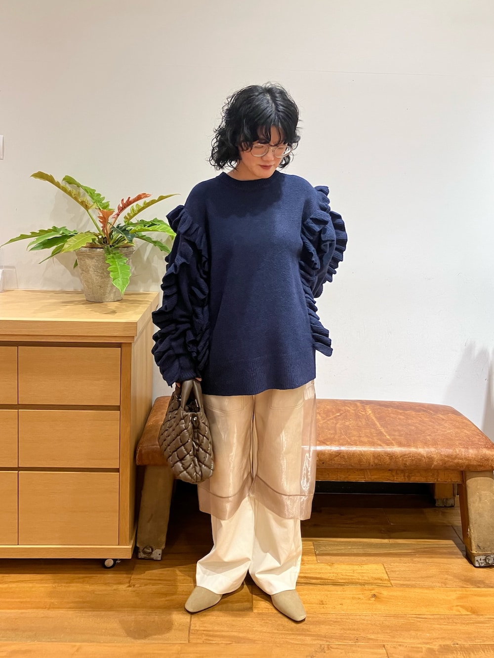 ブラック系のニット/セーター、ベージュ系のローファー、ブラウン系のハンドバッグを着用したレディースの秋コーディネートの3枚目の写真