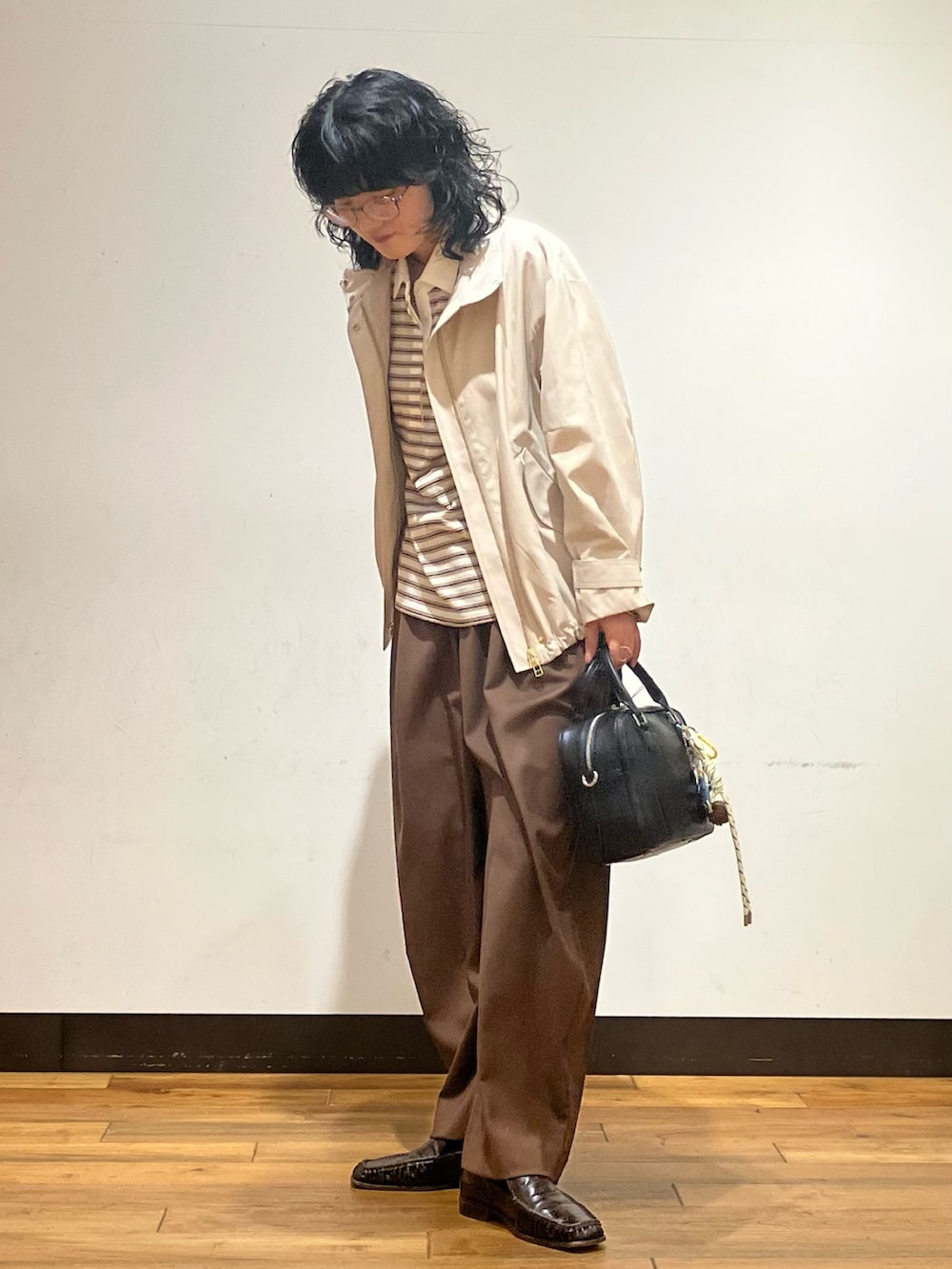 ホワイト系のシャツ/ブラウス、ベージュ系のその他アウター、ブラック系のボストンバッグを着用したレディースの春コーディネートの3枚目の写真