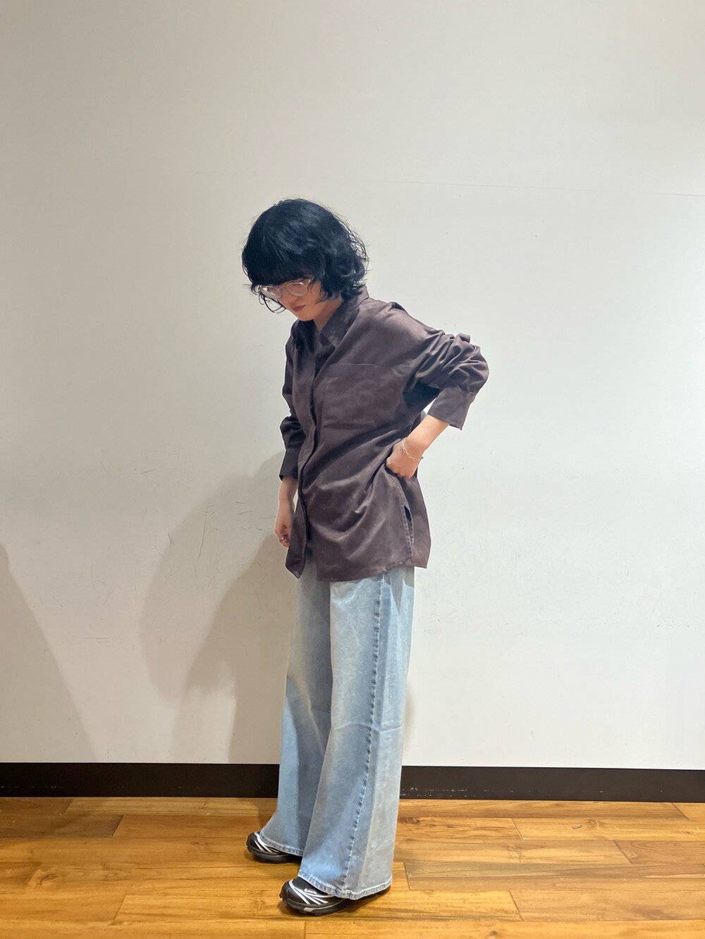 ブルー系のデニムパンツ、ブラウン系のシャツ/ブラウス、ブラック系のショルダーバッグを着用したレディースの秋コーディネートの2枚目の写真