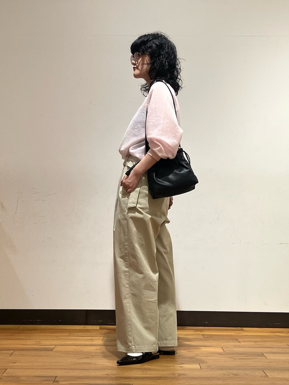 ピンク系のニット/セーター、ベージュ系のその他パンツ、ブラック系のショルダーバッグを着用したレディースの春コーディネートの3枚目の写真