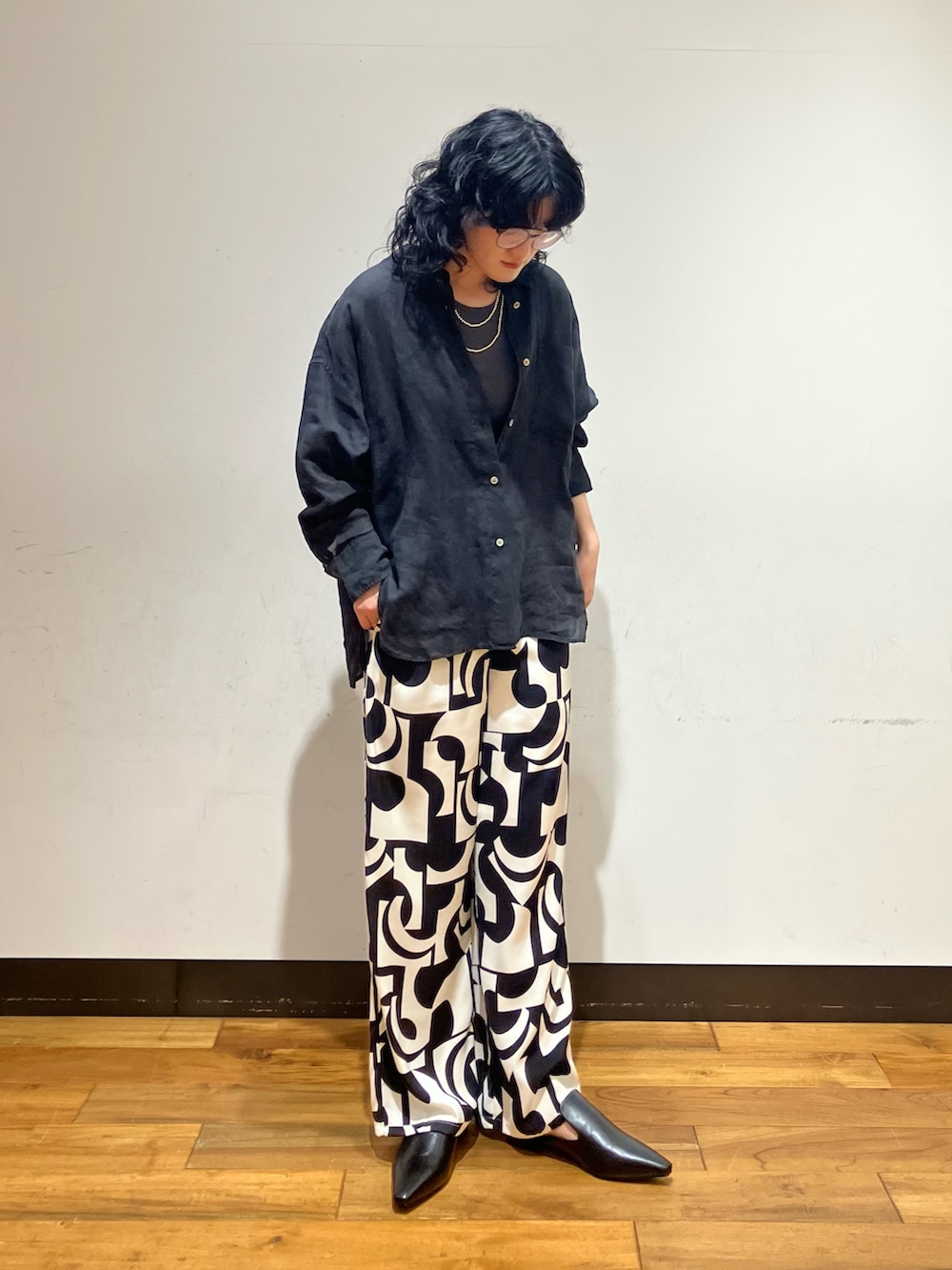 ブラック系のその他パンツ、ブラック系のその他シューズ、グレー系のタンクトップを着用したレディースの春コーディネートの2枚目の写真