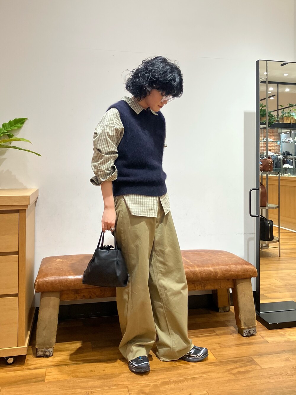 ブラック系のショルダーバッグ、ブラック系のスニーカー、グリーン系のシャツ/ブラウスを着用したレディースの秋コーディネートの3枚目の写真