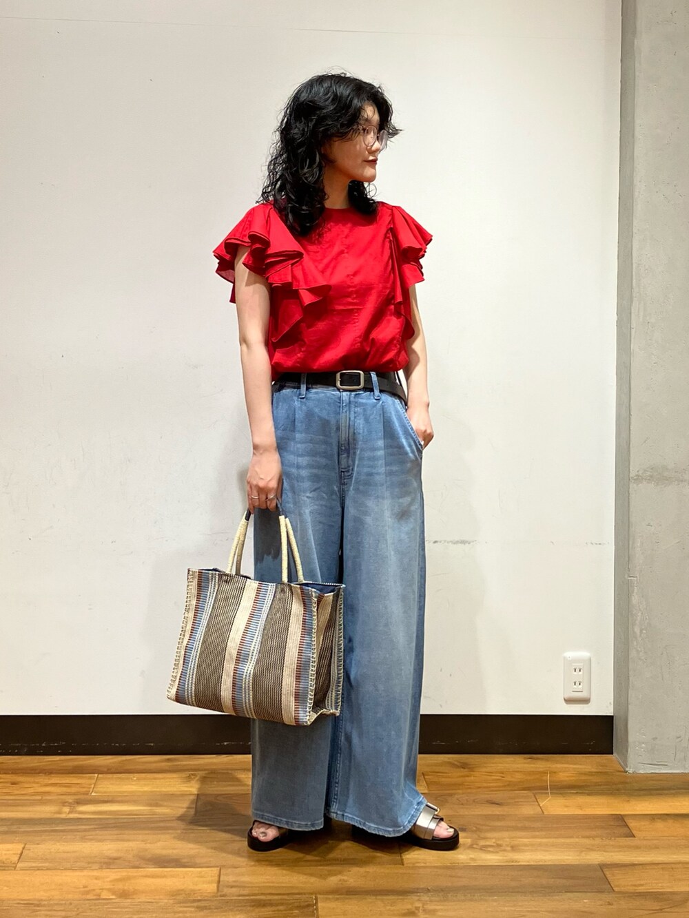 ブルー系のデニムパンツ、レッド系のシャツ/ブラウス、シルバー系のサンダルを着用したレディースの夏コーディネートの4枚目の写真