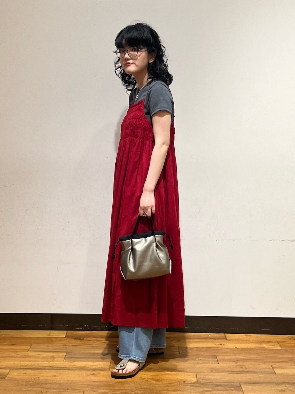 ブルー系のデニムパンツ、ベージュ系のサンダル、グレー系のTシャツ/カットソーを着用したレディースの春コーディネートの2枚目の写真