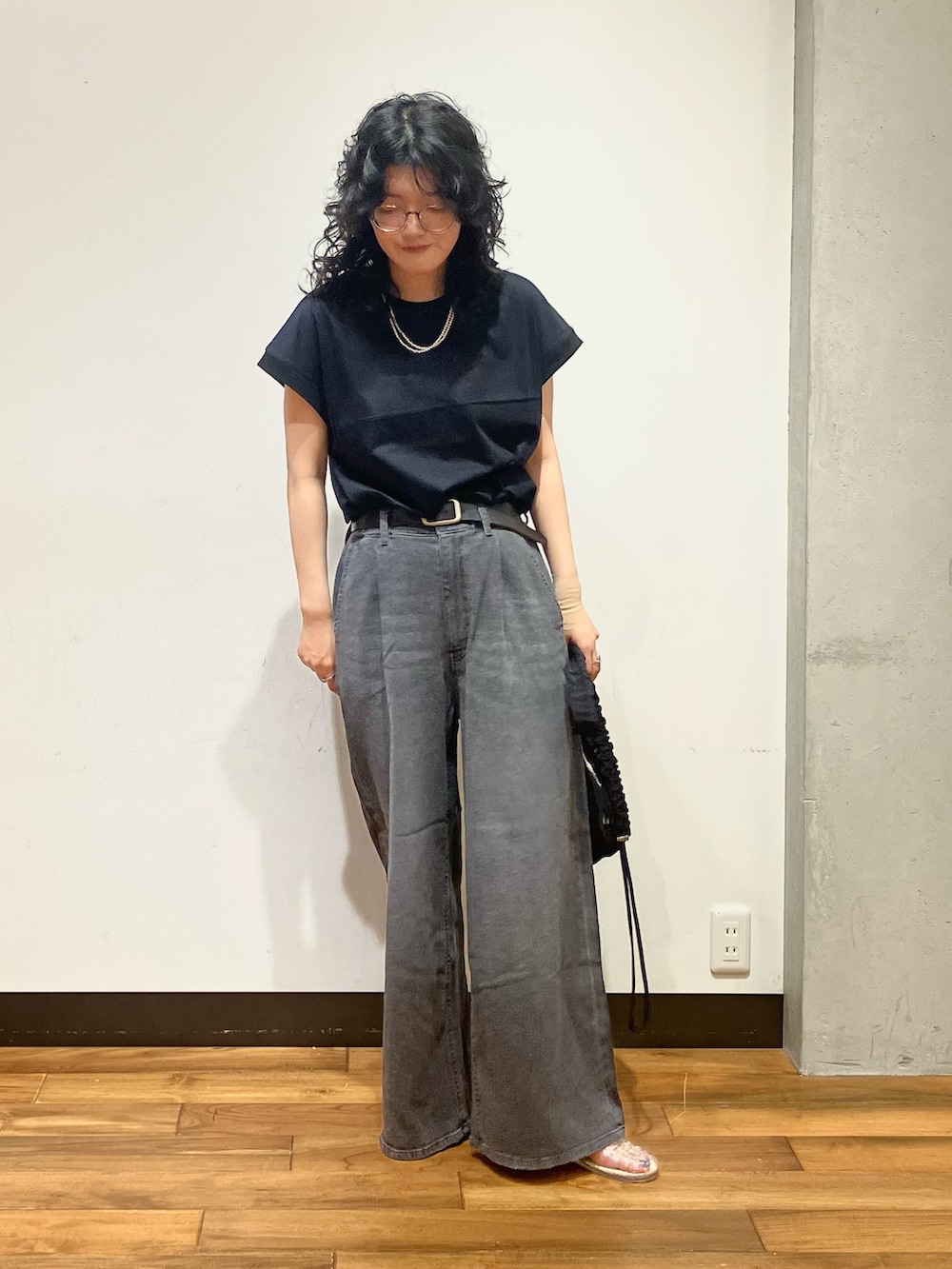 ブラック系のデニムパンツ、その他のサンダル、ブラック系のショルダーバッグを着用したレディースの夏コーディネートの3枚目の写真