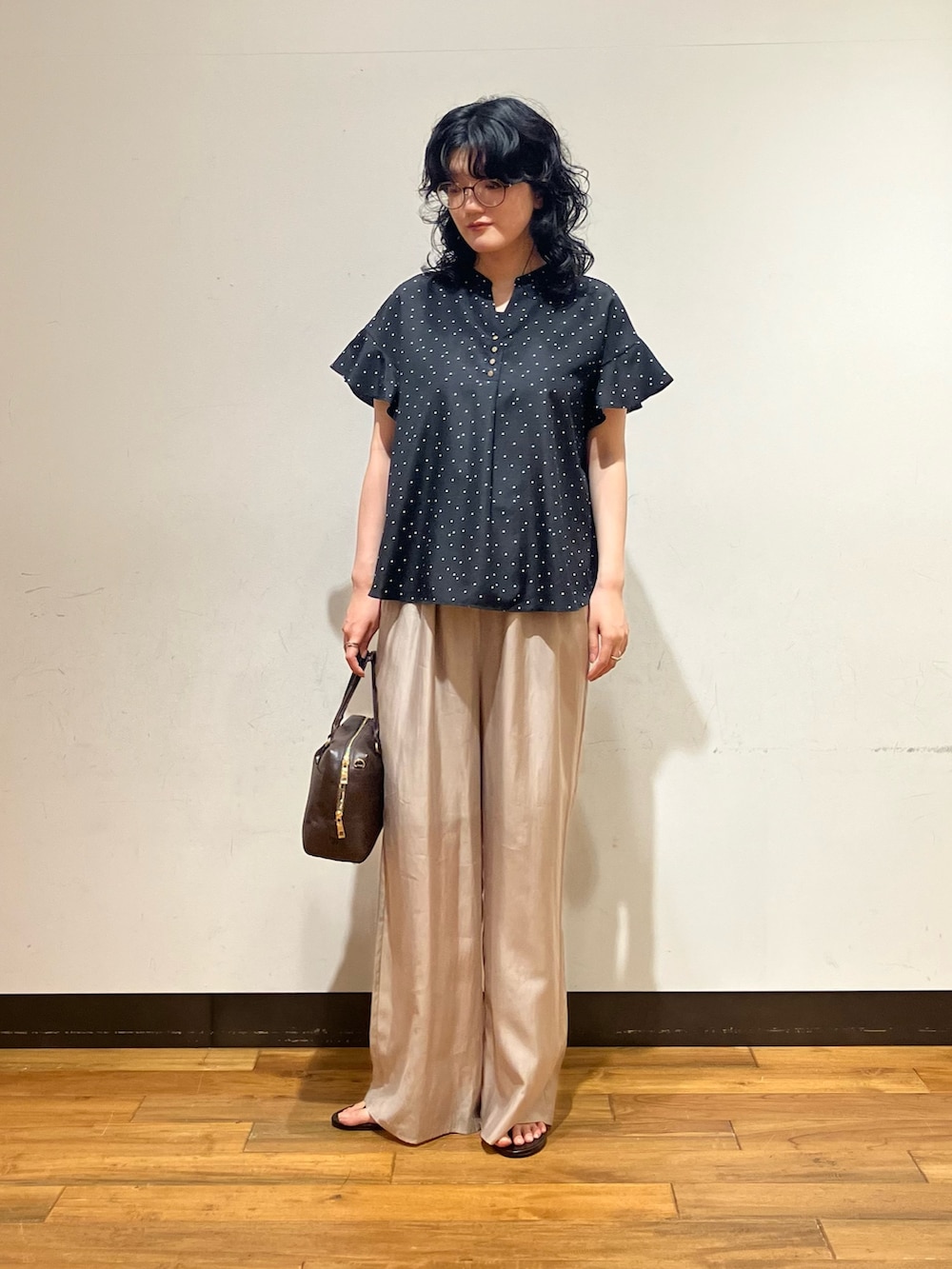 ブラック系のシャツ/ブラウス、ベージュ系のその他パンツ、ブラウン系のボストンバッグを着用したレディースの夏コーディネートの3枚目の写真