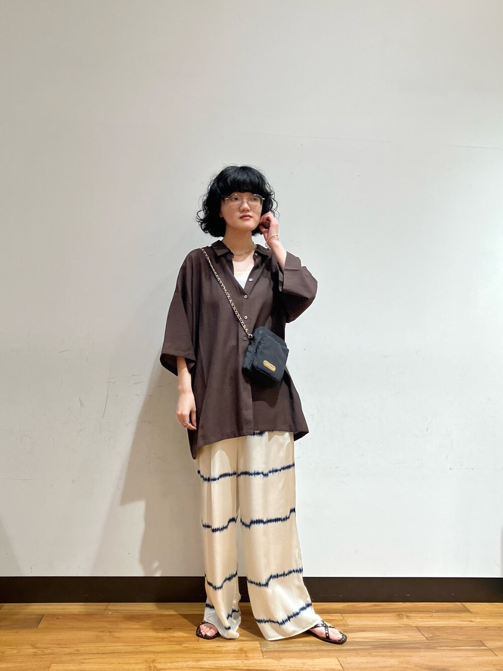 ホワイト系のその他パンツ、ブラウン系のシャツ/ブラウス、ブラック系のショルダーバッグを着用したレディースの夏コーディネートの2枚目の写真