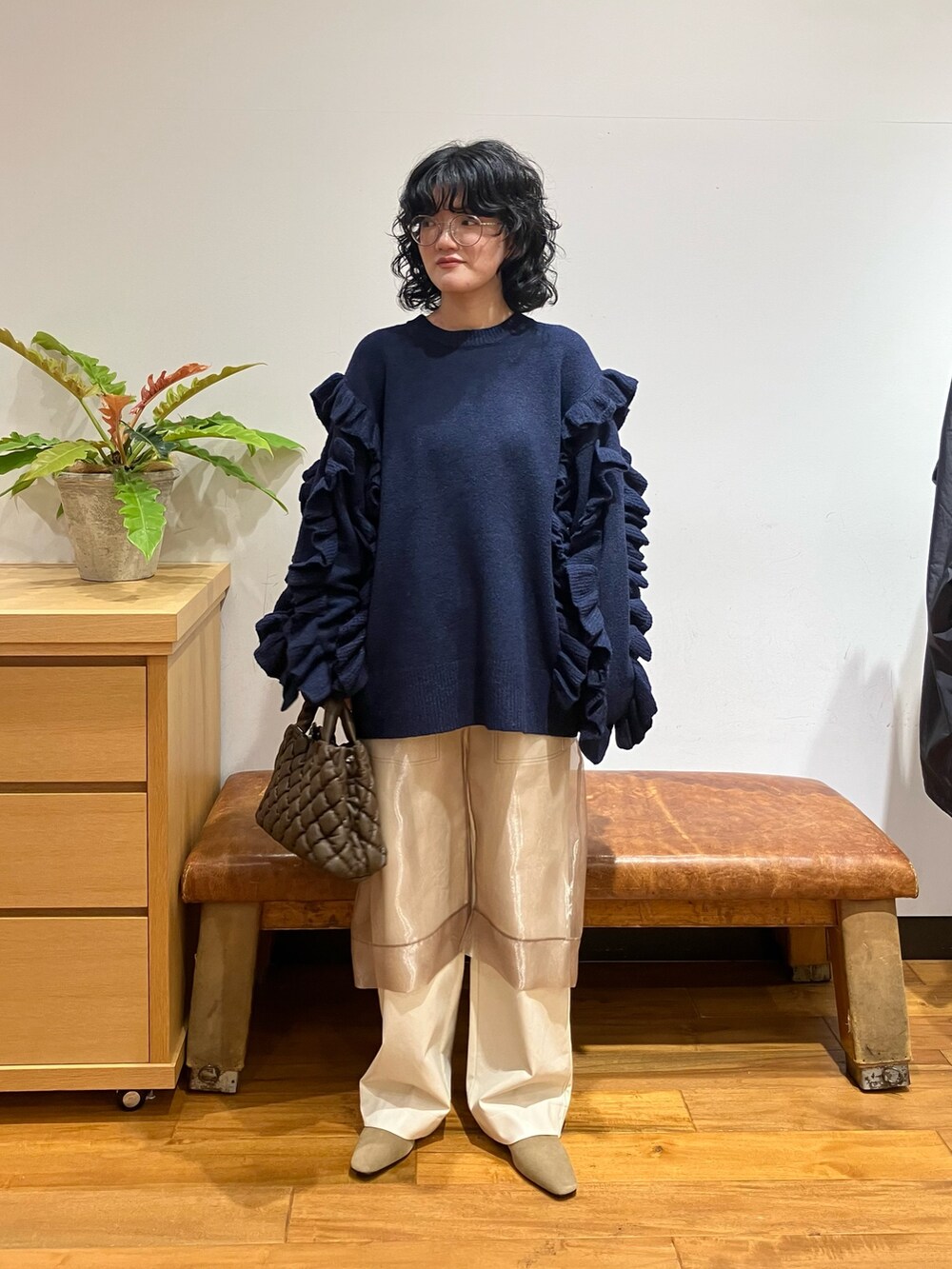 ブラック系のニット/セーター、ベージュ系のローファー、ブラウン系のハンドバッグを着用したレディースの秋コーディネートの2枚目の写真