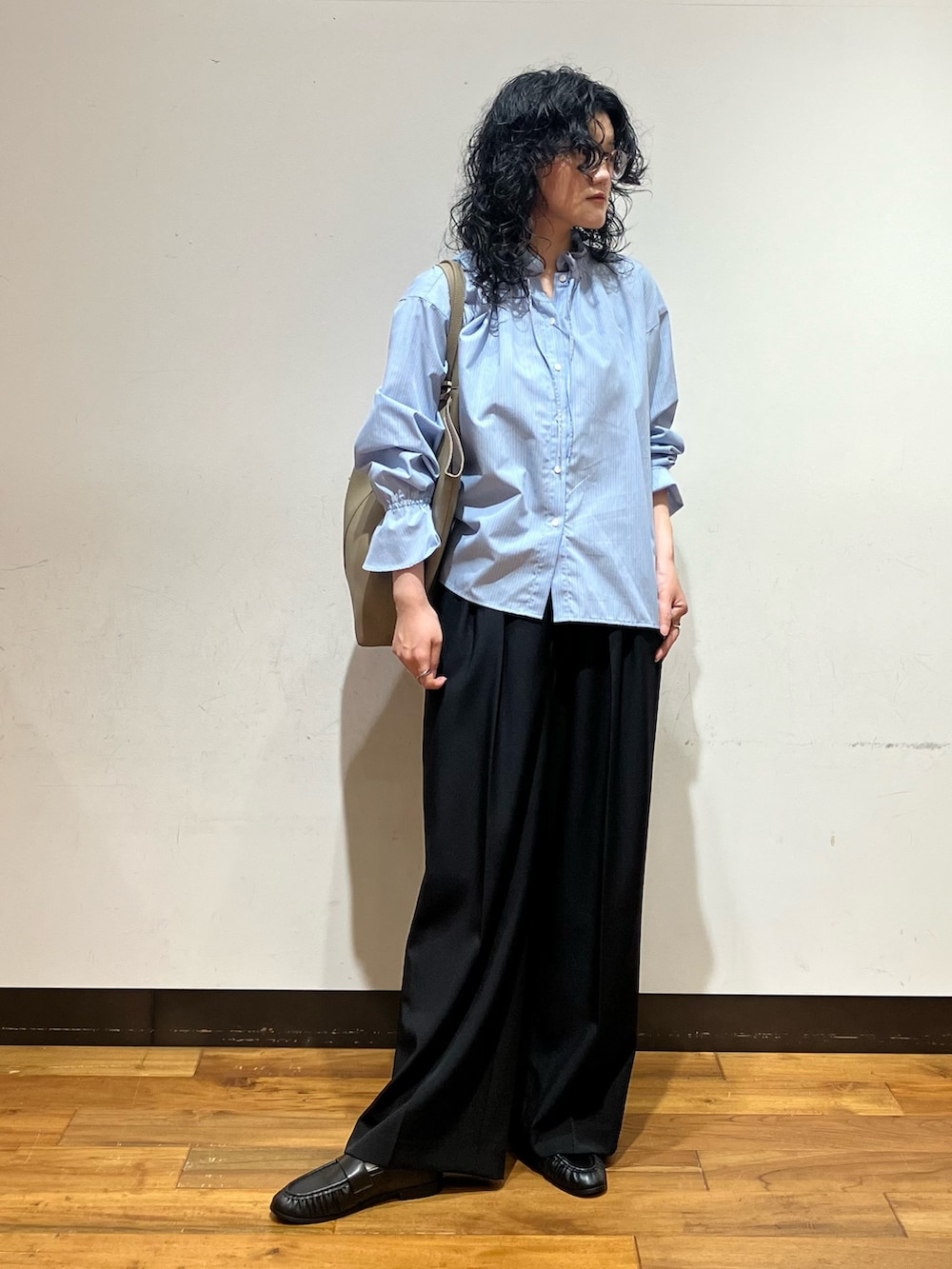 ブラック系のその他パンツ、ベージュ系のトートバッグ、ブルー系のシャツ/ブラウスを着用したレディースの秋コーディネートの2枚目の写真