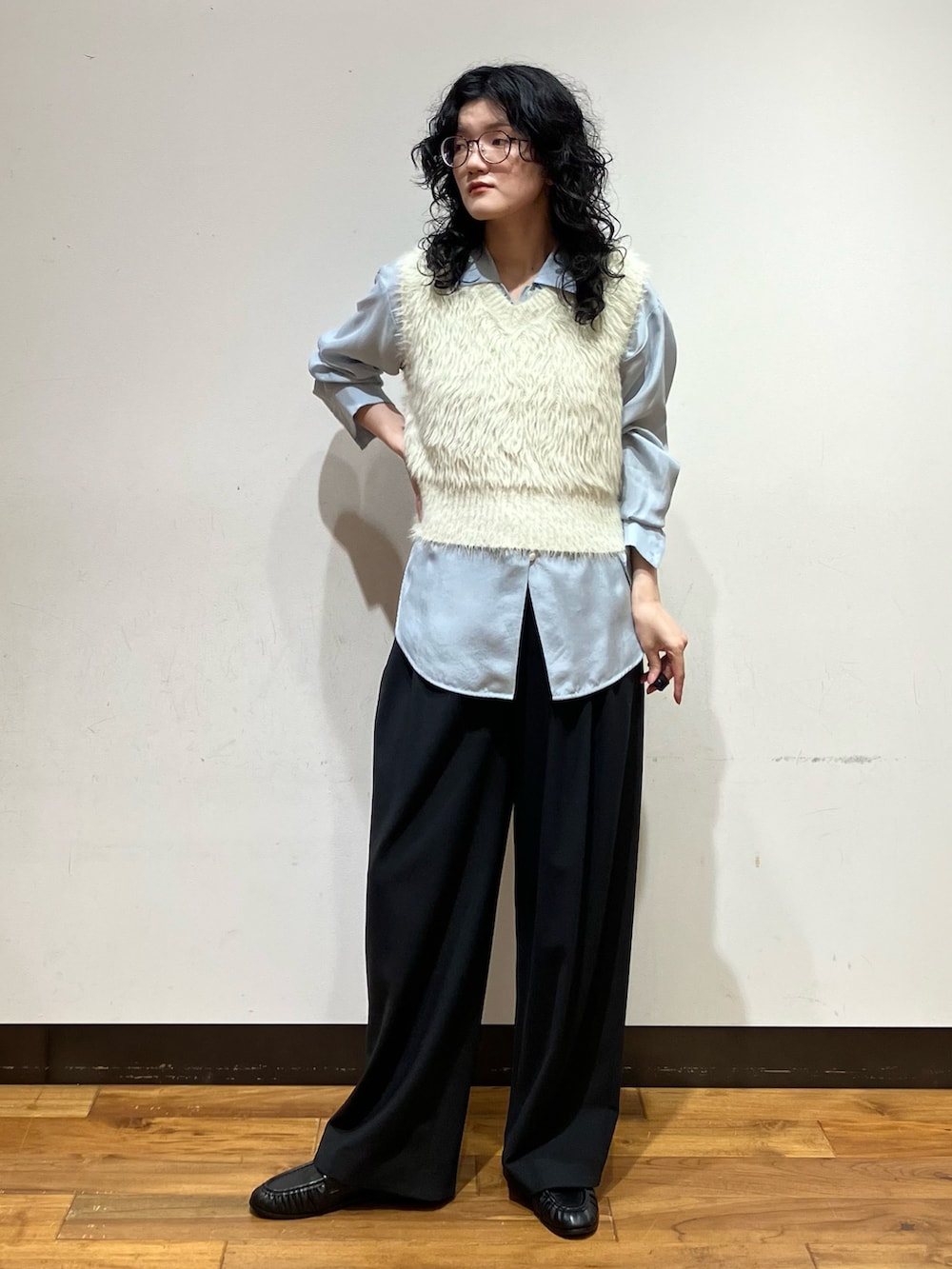 ブルー系のシャツ/ブラウス、ホワイト系のベスト、ブラック系のその他パンツを着用したレディースの秋コーディネートの2枚目の写真