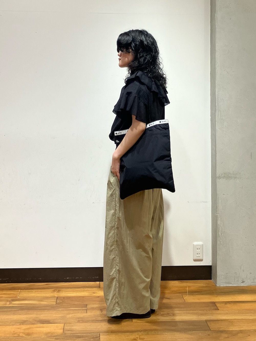 ブラック系のシャツ/ブラウス、ベージュ系のその他パンツ、ブラック系のトートバッグを着用したレディースの夏コーディネートの2枚目の写真