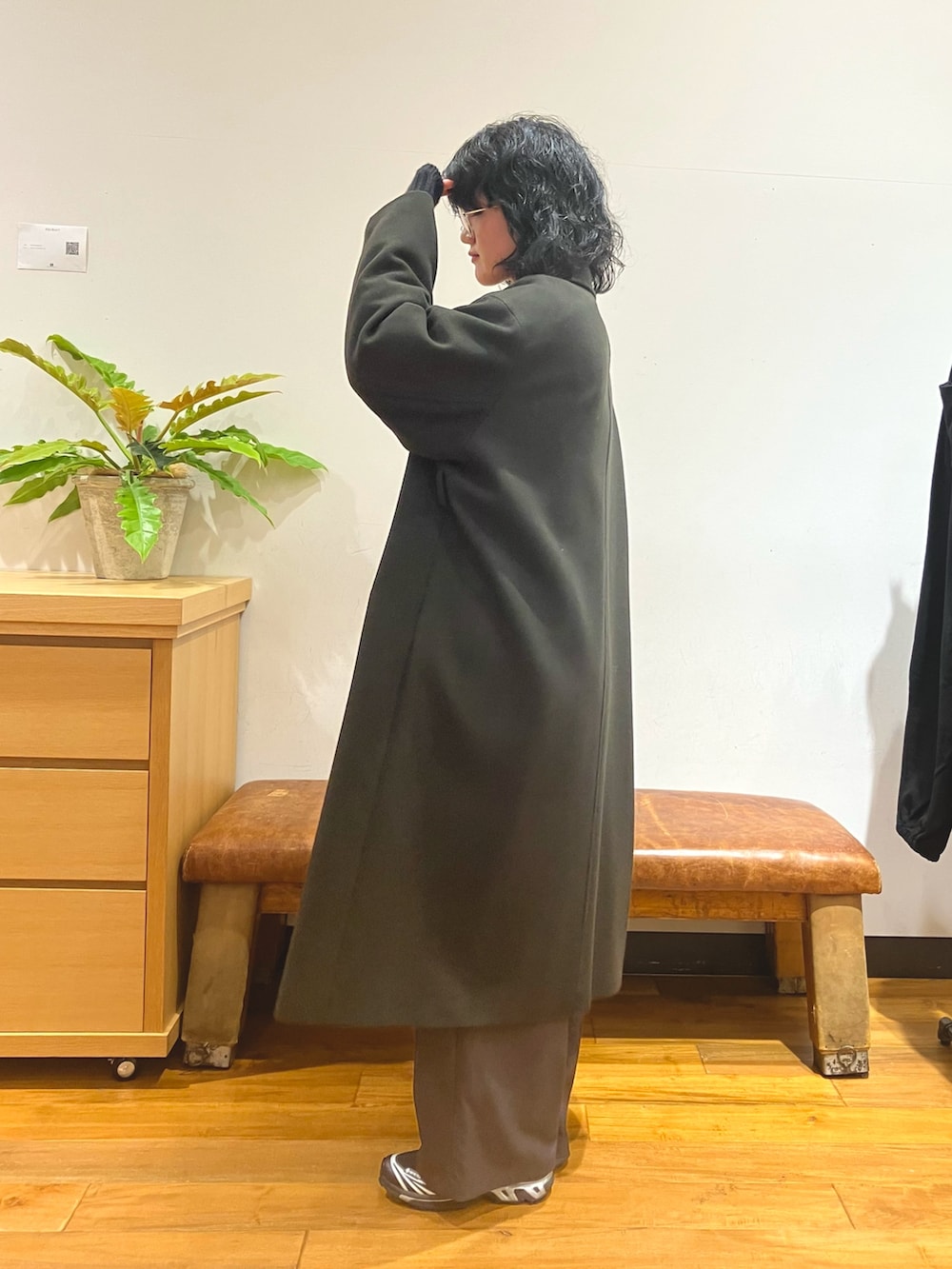 グリーン系のチェスターコート、ブラック系のニット/セーター、グレー系のその他パンツを着用したレディースの冬コーディネートの3枚目の写真