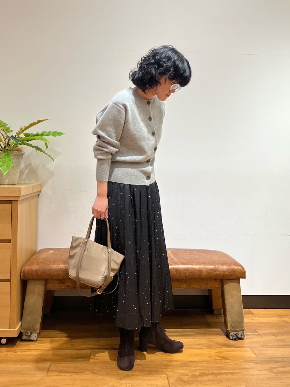 グレー系のカーディガン/ボレロ、ブラック系のスカート、ベージュ系のショルダーバッグを着用したレディースの秋コーディネートの2枚目の写真