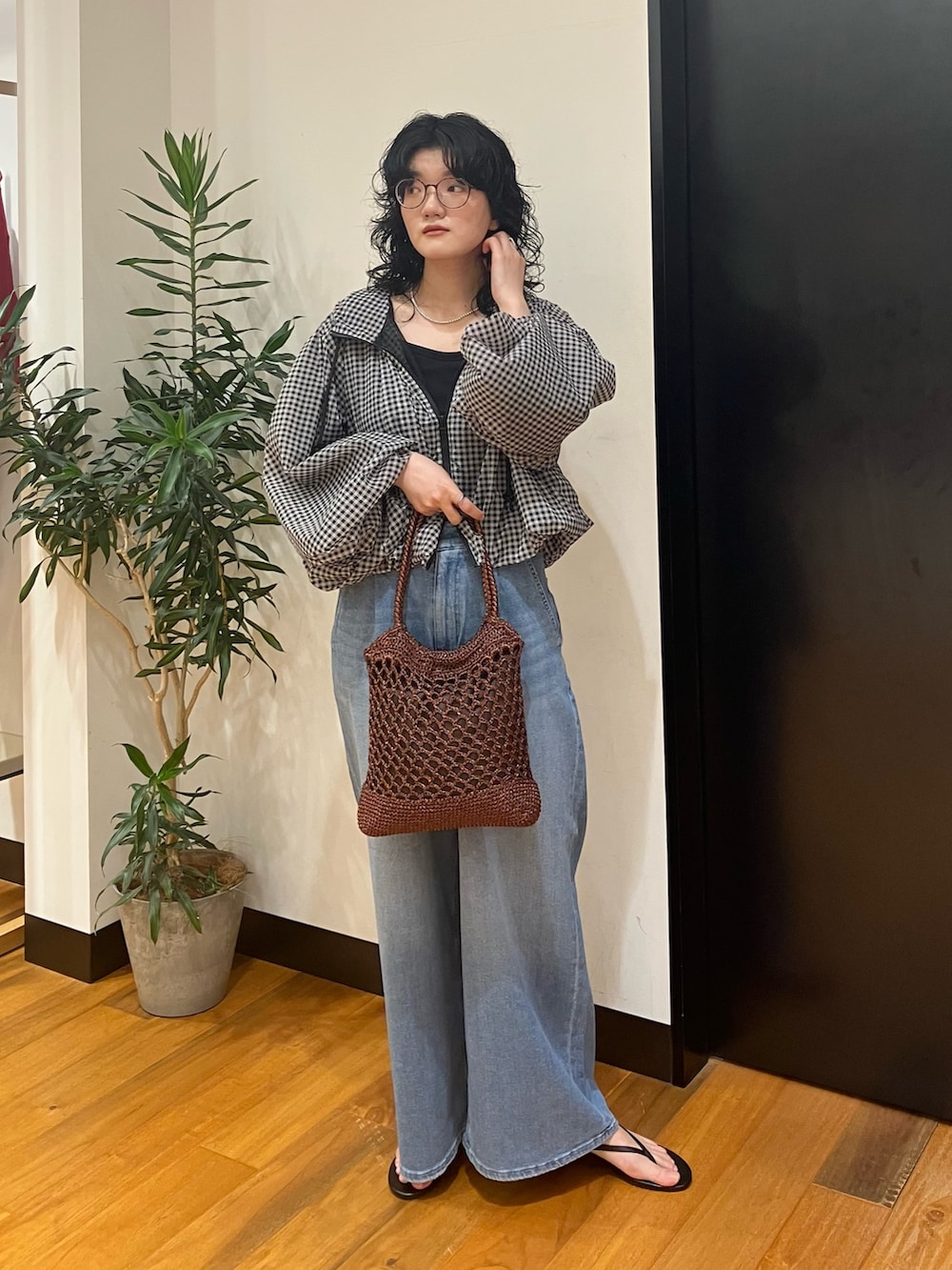 ブラウン系のトートバッグ、ブルー系のデニムパンツ、その他のブルゾンを着用したレディースの春コーディネートの3枚目の写真