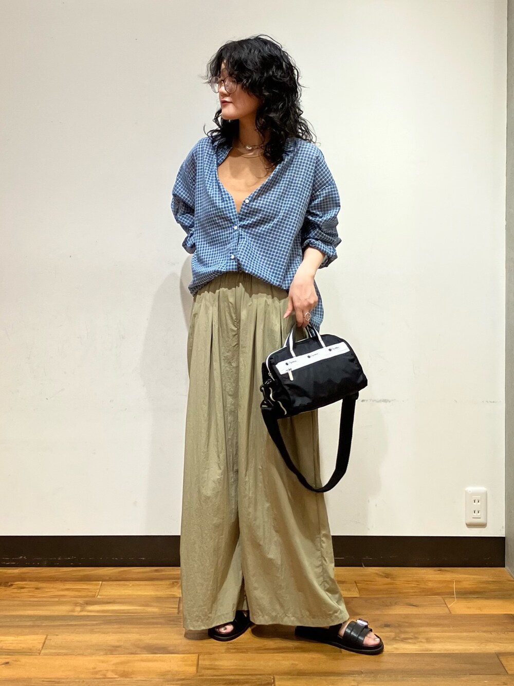 ブラック系のサンダル、ベージュ系のその他パンツ、ブルー系のシャツ/ブラウスを着用したレディースの夏コーディネートの3枚目の写真