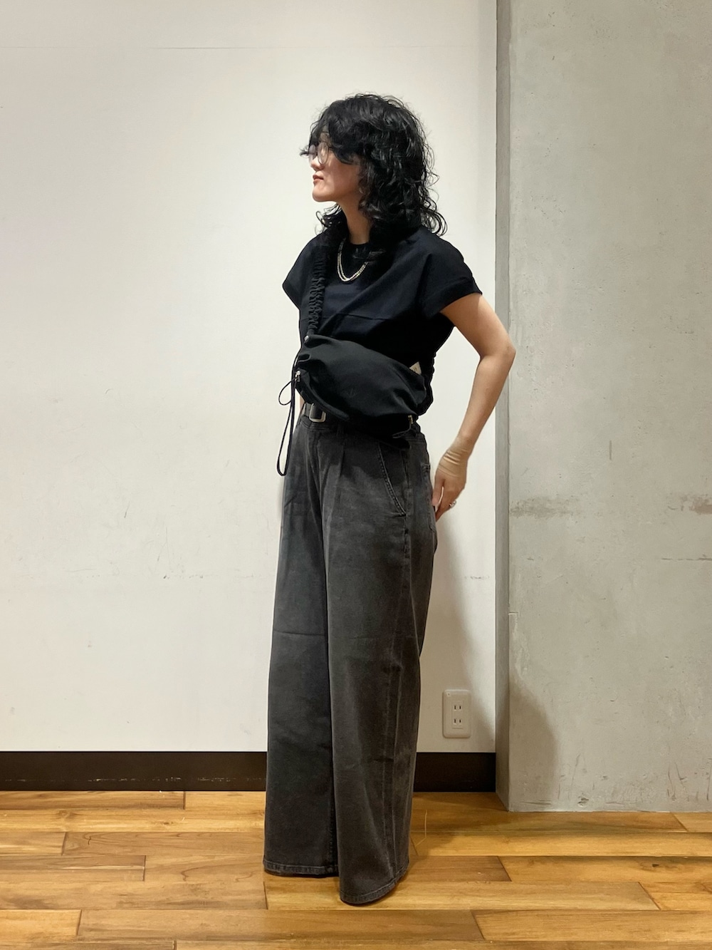 ブラック系のデニムパンツ、その他のサンダル、ブラック系のショルダーバッグを着用したレディースの夏コーディネートの2枚目の写真