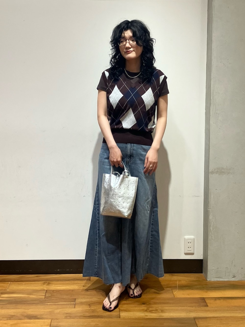 ブラウン系のベスト、ブラウン系のTシャツ/カットソー、シルバー系のトートバッグを着用したレディースの夏コーディネートの3枚目の写真