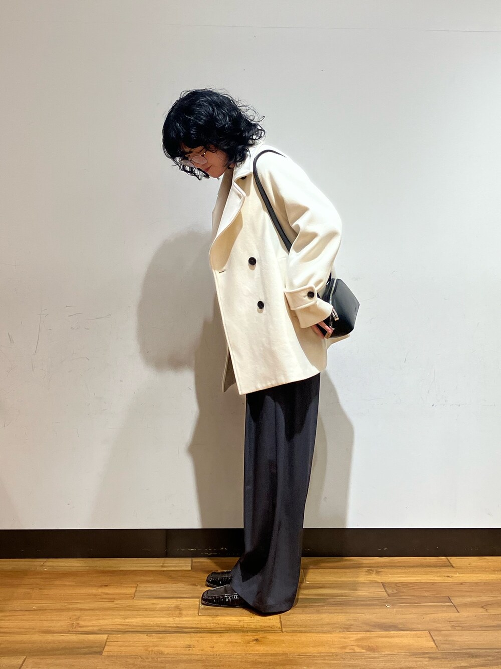 グレー系のその他パンツ、ブラック系のショルダーバッグ、ホワイト系のピーコートを着用したレディースの冬コーディネートの2枚目の写真