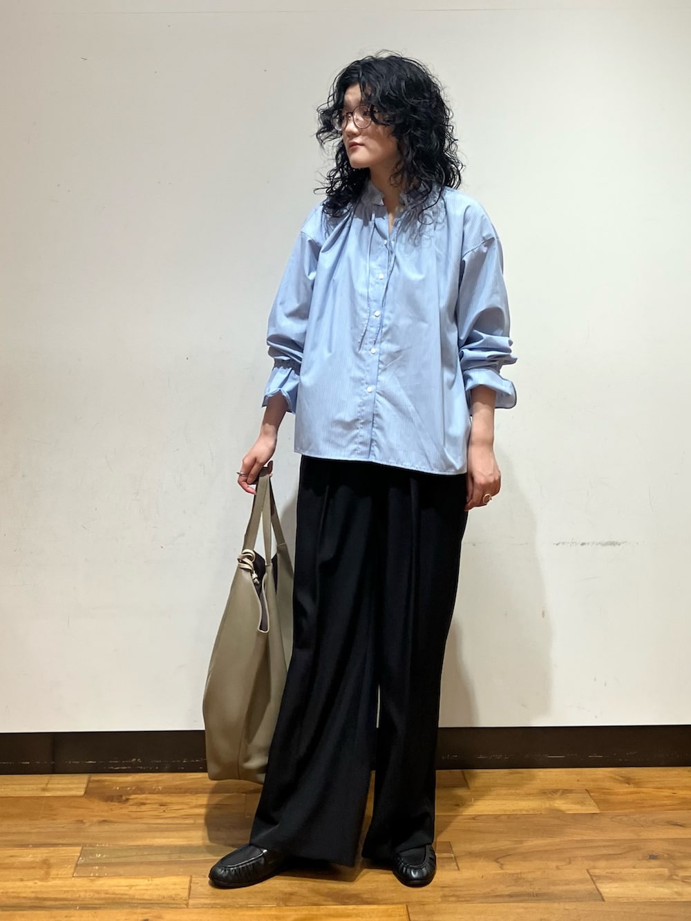 ブラック系のその他パンツ、ベージュ系のトートバッグ、ブルー系のシャツ/ブラウスを着用したレディースの秋コーディネートの3枚目の写真