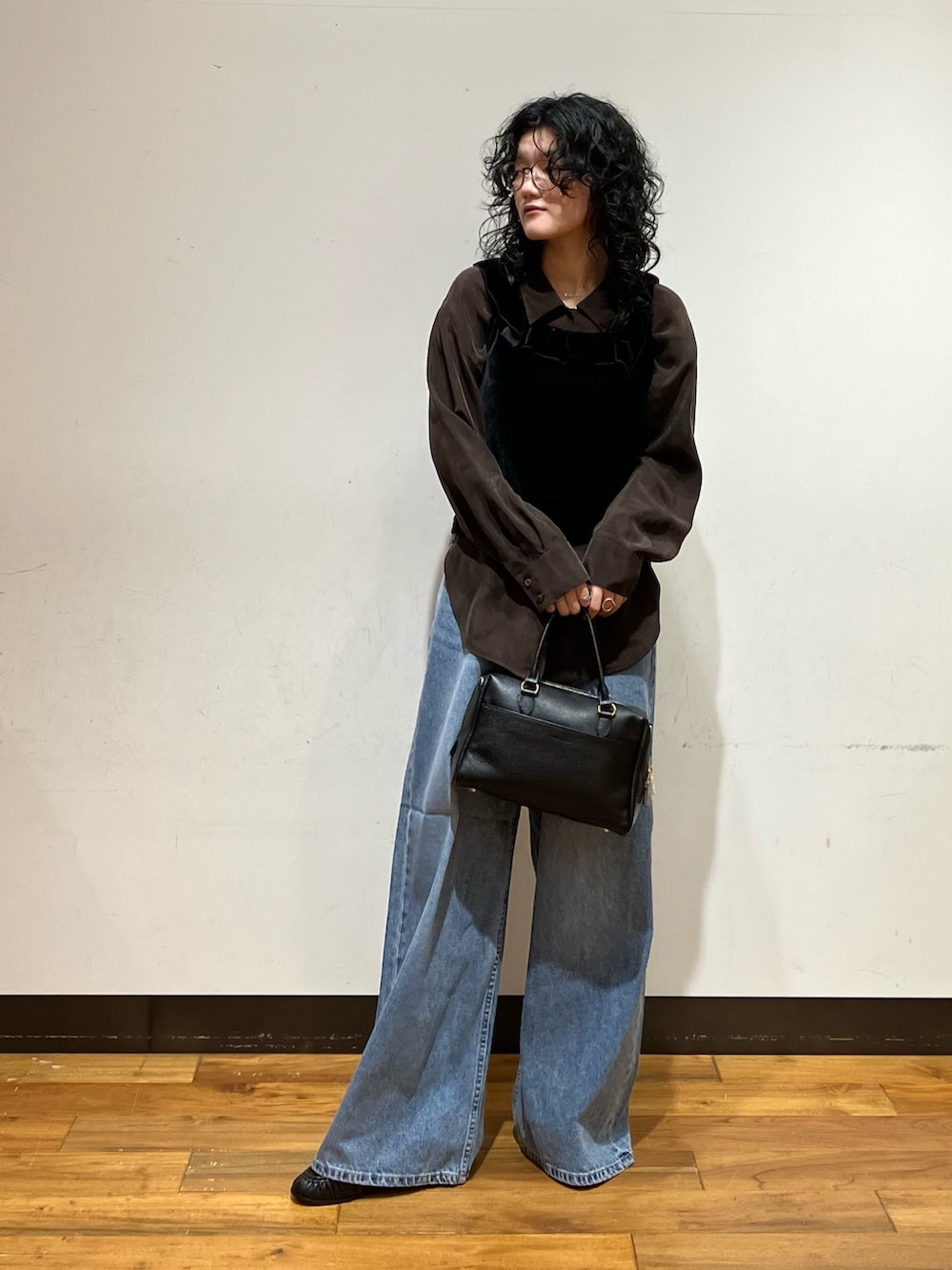 ブラック系のボストンバッグ、ブラウン系のシャツ/ブラウス、ブラック系のその他トップスを着用したレディースの秋コーディネートの2枚目の写真